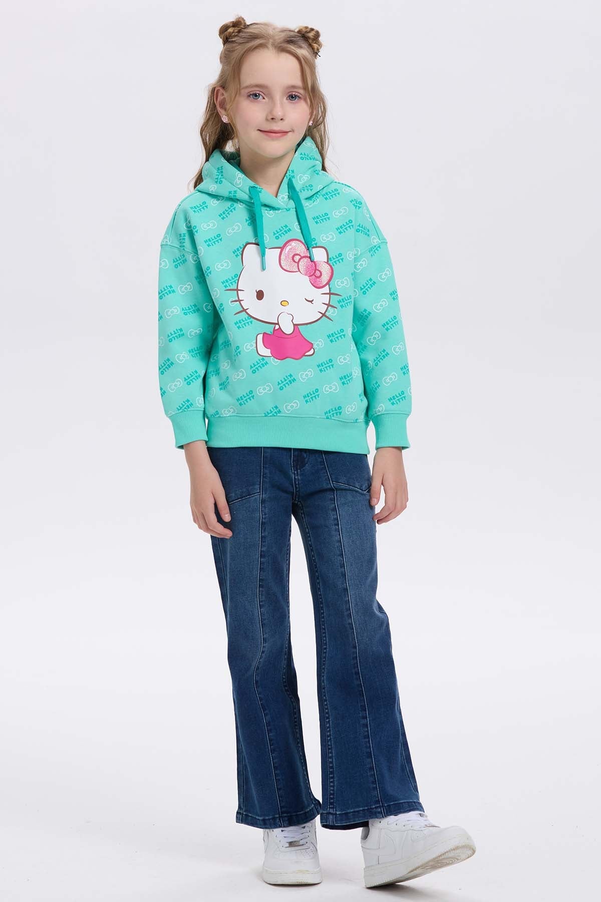 Polerón verde menta con estampado de Hello Kitty en el centro, mostrando su icónica pose con vestido rosa y fondo de patrones de la marca.
