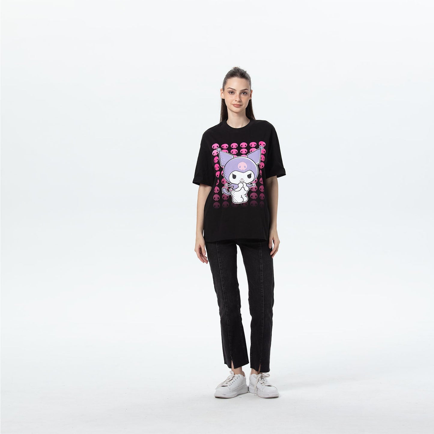 Polera oversize negra con ilustración de Kuromi en tonos púrpura y rosa, rodeada de calaveritas, perfecta para fans de Sanrio.