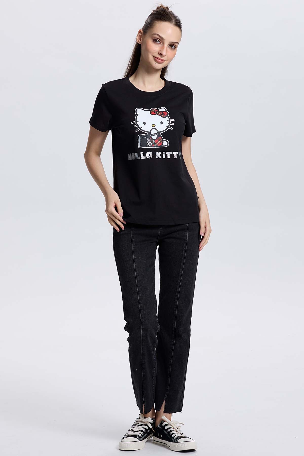Polera negra de algodón con ilustración de Hello Kitty en un estilo moderno, mostrando a la icónica gatita con un lazo rojo y un micrófono, perfecta para fans.
