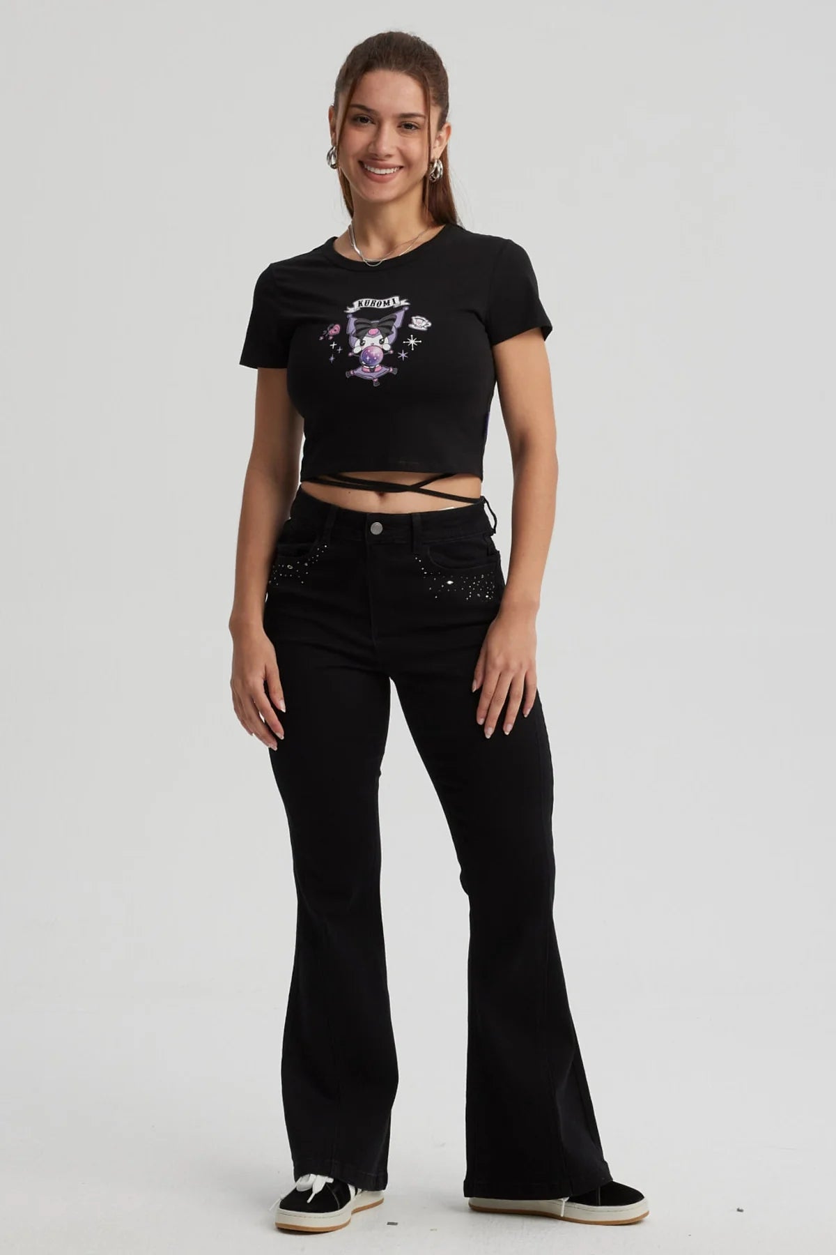 Polera negra ajustada con estampado de Kuromi en tonos morados y rosa, mostrando a la icónica personaje en acción, perfecta para fans de Sanrio.