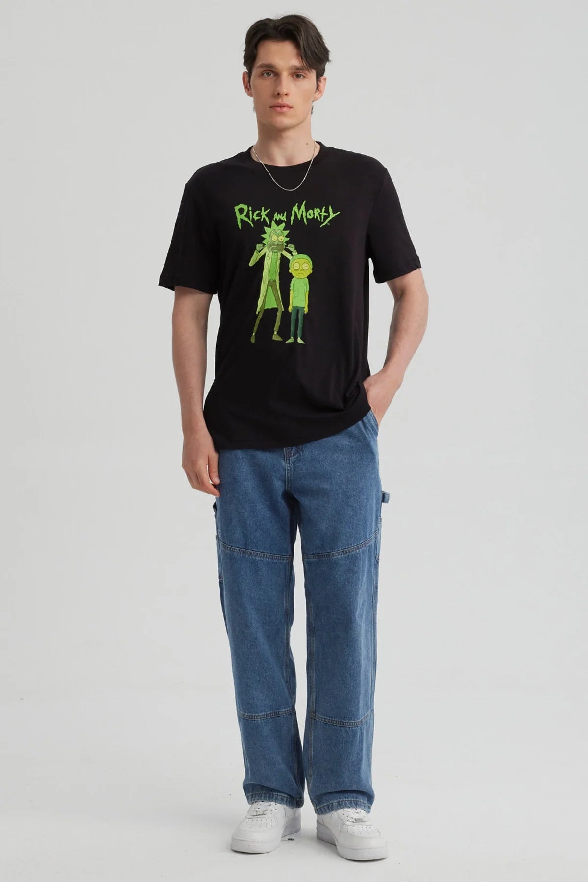 Polera negra de algodón con ilustración de Rick y Morty en verde, mostrando a Rick con su expresión característica y Morty luciendo asustado, ideal para fans de la serie.