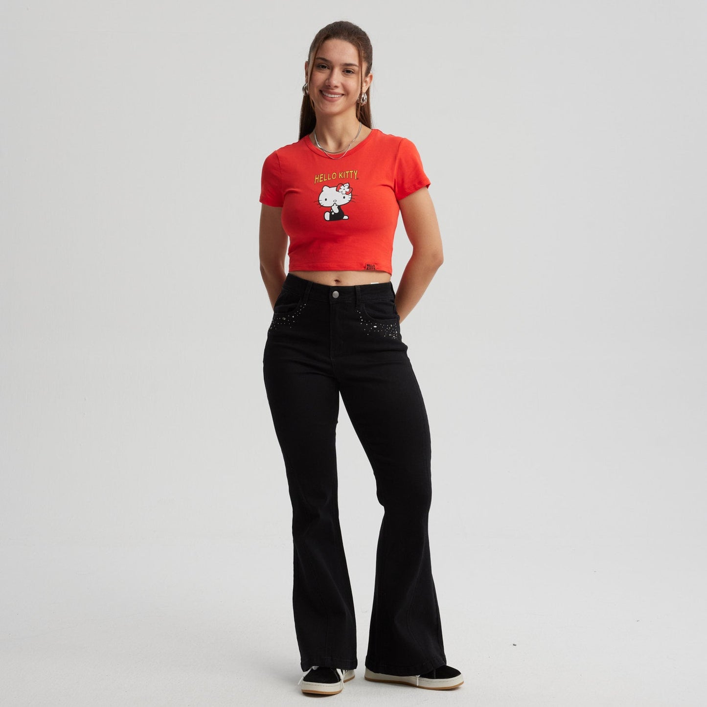 Polera roja de algodón con un diseño de Hello Kitty en estilo cartoon, destacando su lazo rojo y la frase 'HELLO KITTY', ideal para fans del universo Sanrio.