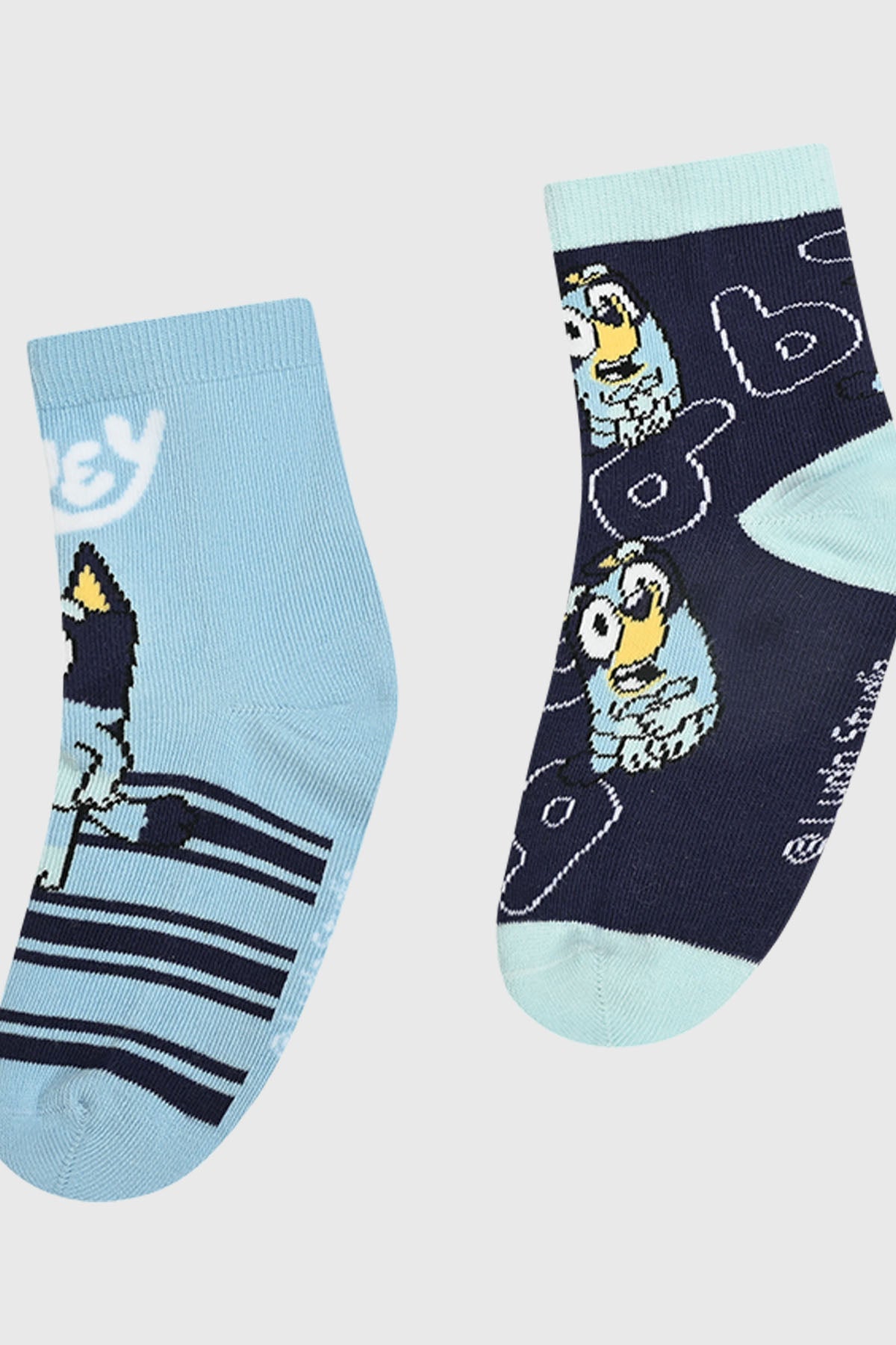 Calcetín bipack en tonos azules, uno con diseño de Bluey y rayas, el otro con ilustración divertida de Bluey sobre fondo azul marino, ideal para fans.