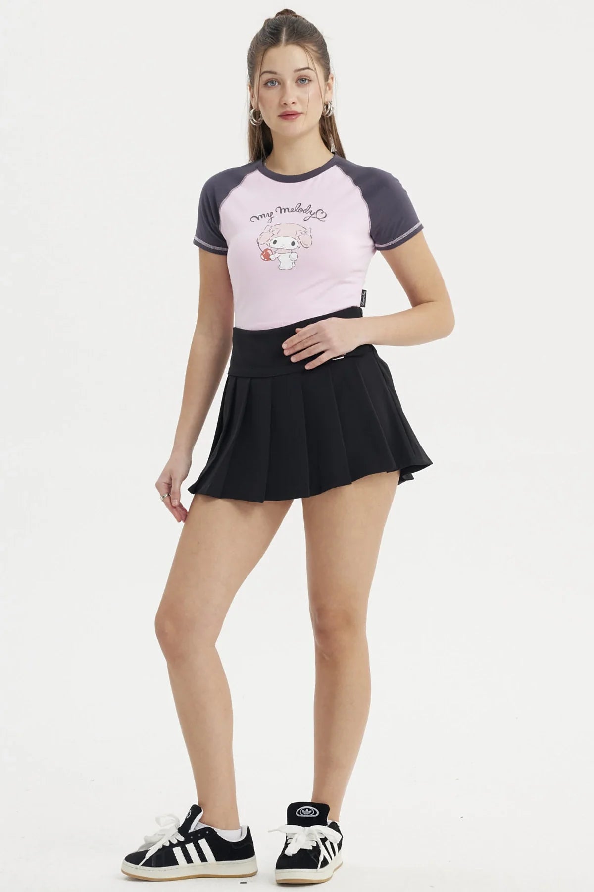 Polera rosa de My Melody con detalles en azul marino, presenta una ilustración de la adorable conejita sosteniendo un dulce, ideal para fans de Sanrio.