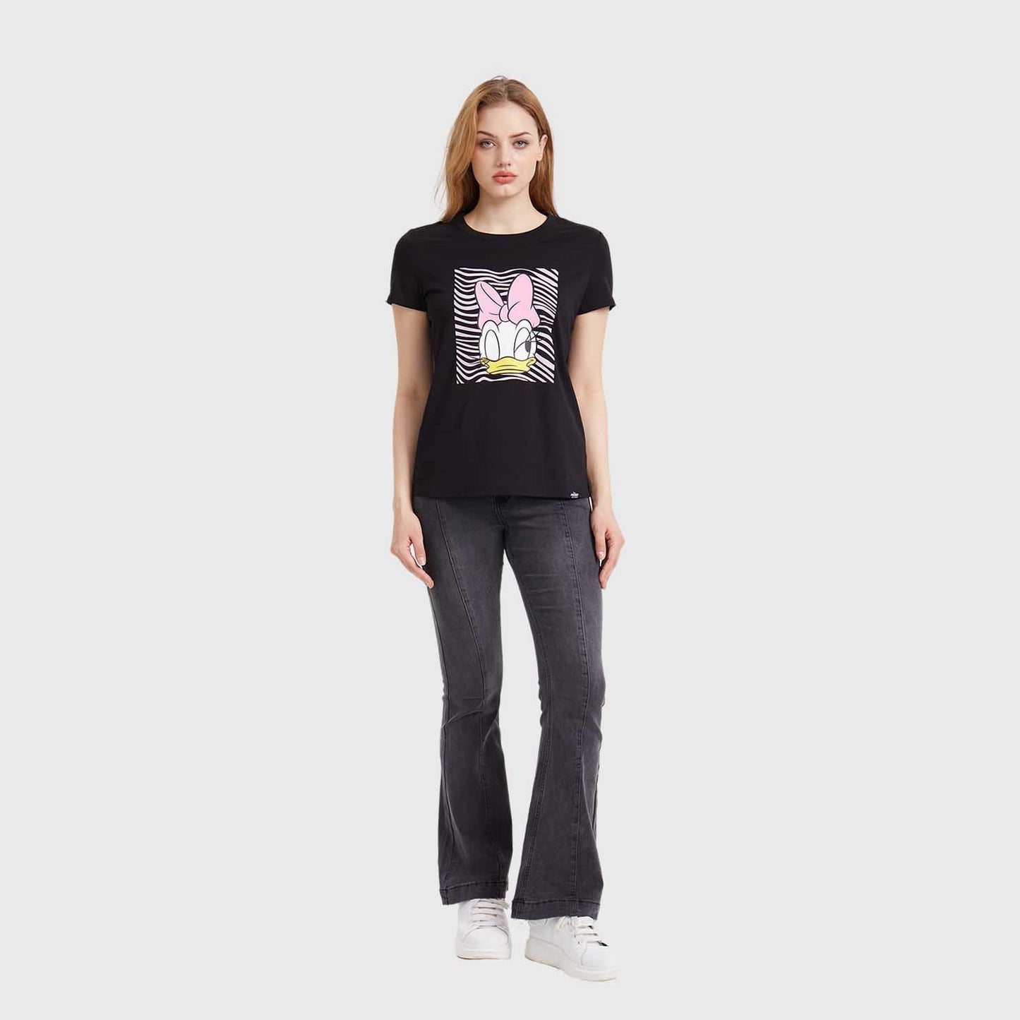 Polera negra de algodón con un diseño vibrante de Daisy Duck en el centro, destacando su icónico moño rosa sobre un fondo de rayas en blanco y negro.