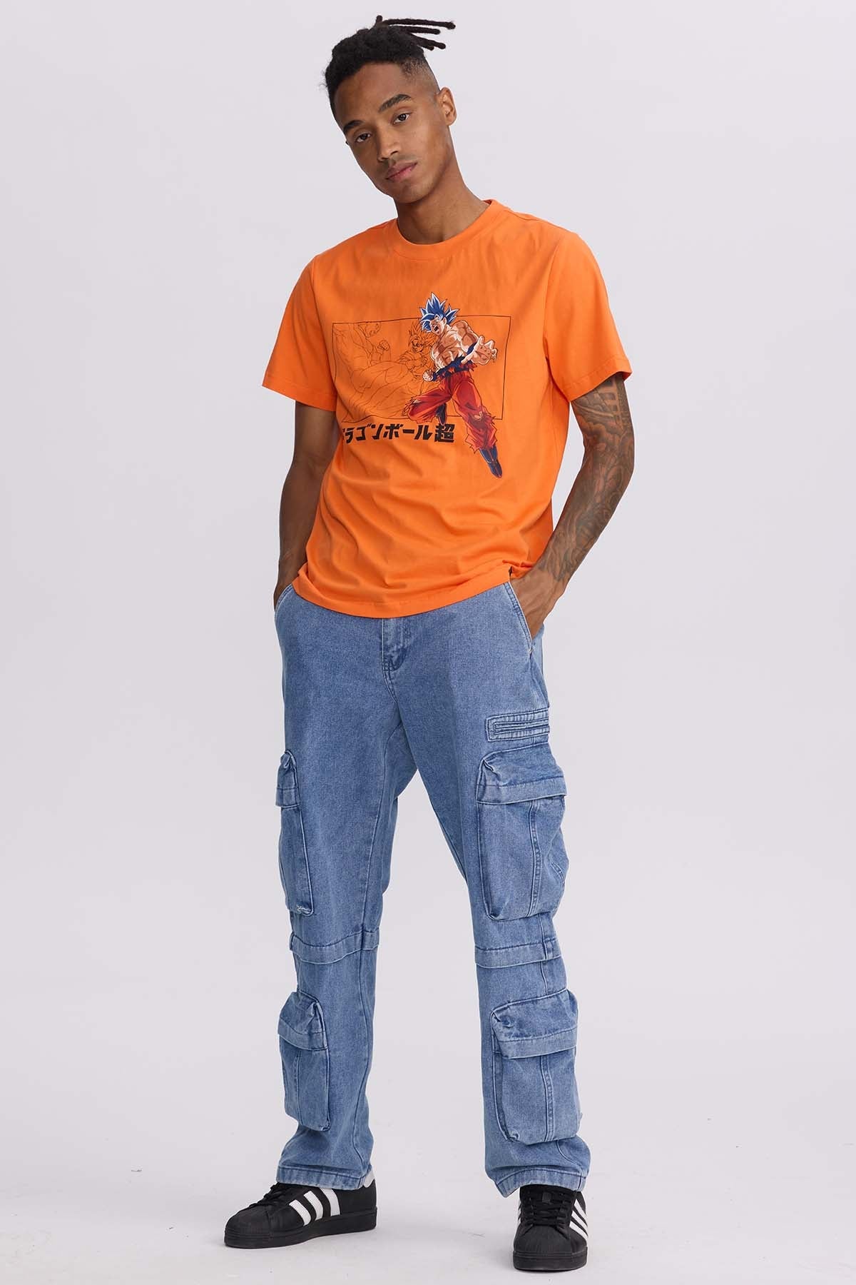 Polera naranja de algodón con ilustración de Goku en su forma Super Saiyan Blue, mostrando su energía en acción, con detalles en negro y texto japonés.