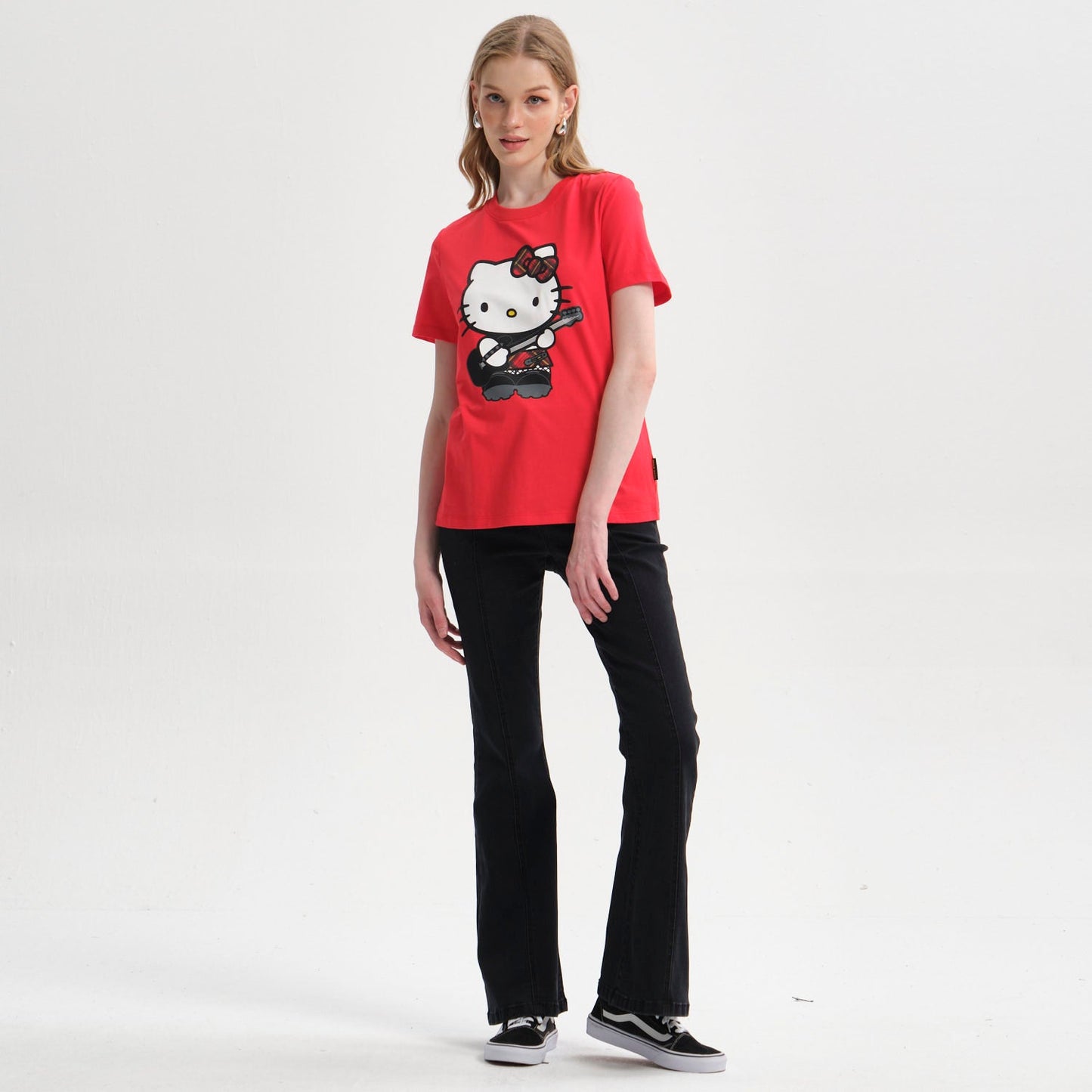 Polera roja de algodón con estampado de Hello Kitty tocando guitarra, diseño vibrante y divertido que captura la esencia de la cultura pop japonesa.