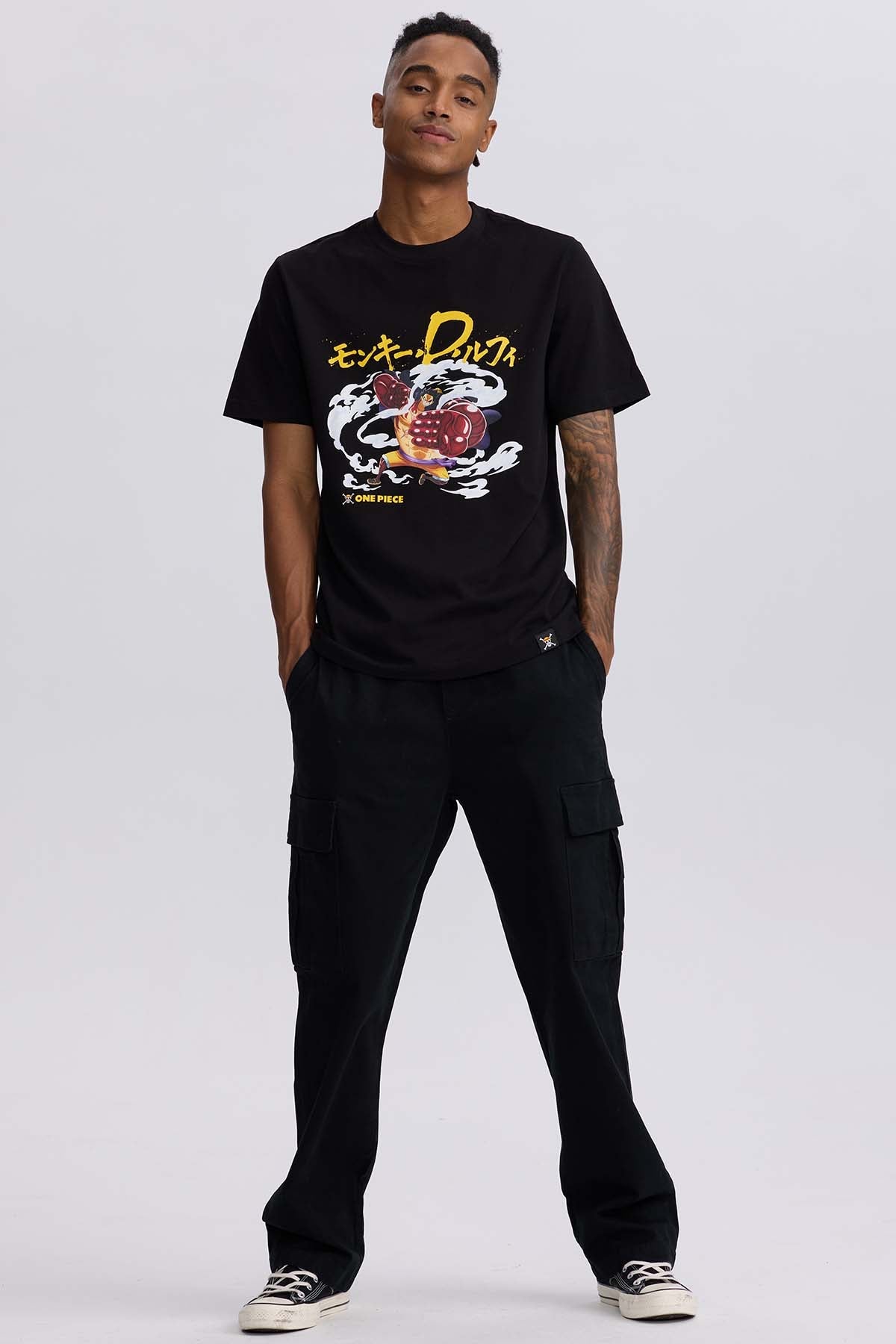 Polera negra de algodón con estampado de Luffy en su forma Gear 4, mostrando puños gigantes y nubes de energía, destacando el título 'One Piece'.