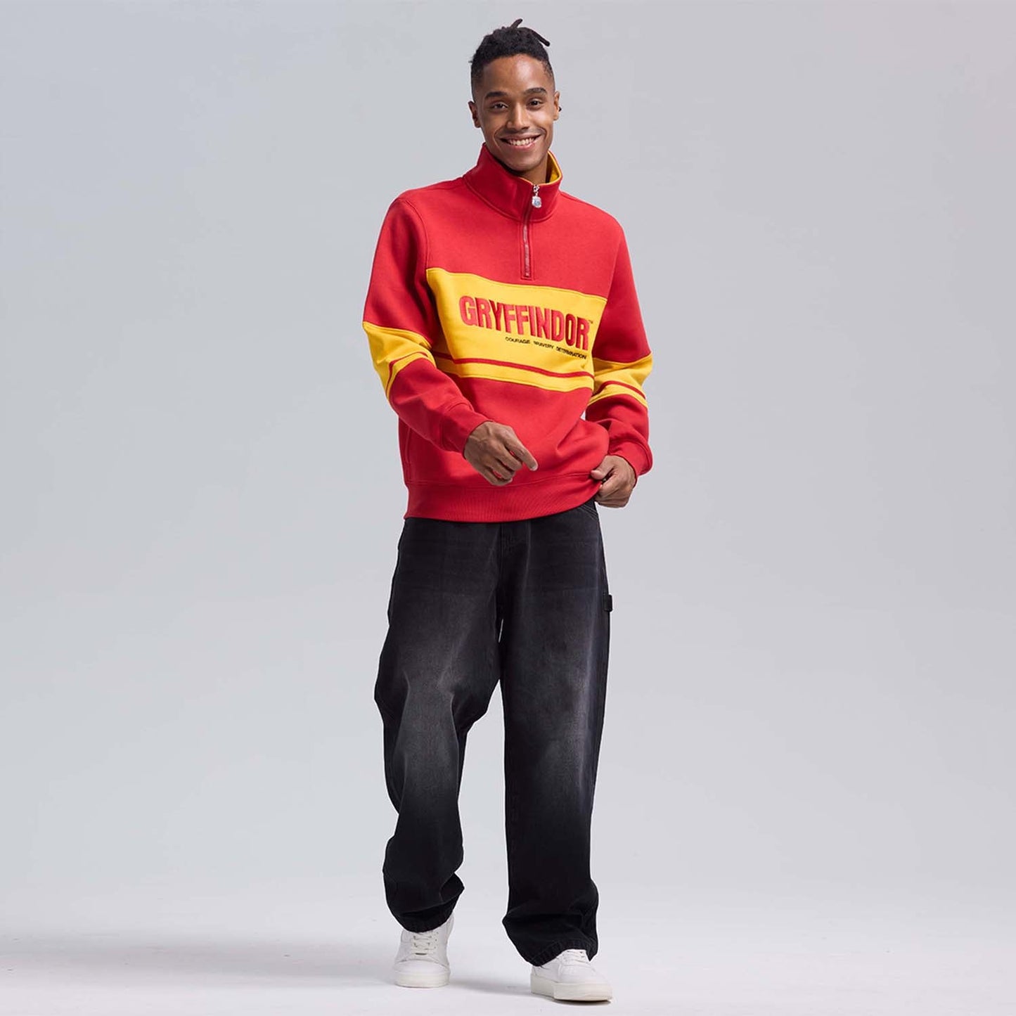 Polerón rojo de Gryffindor con franjas amarillas y el logo en letras grandes, ideal para mostrar tu valentía en el mundo mágico de Harry Potter.