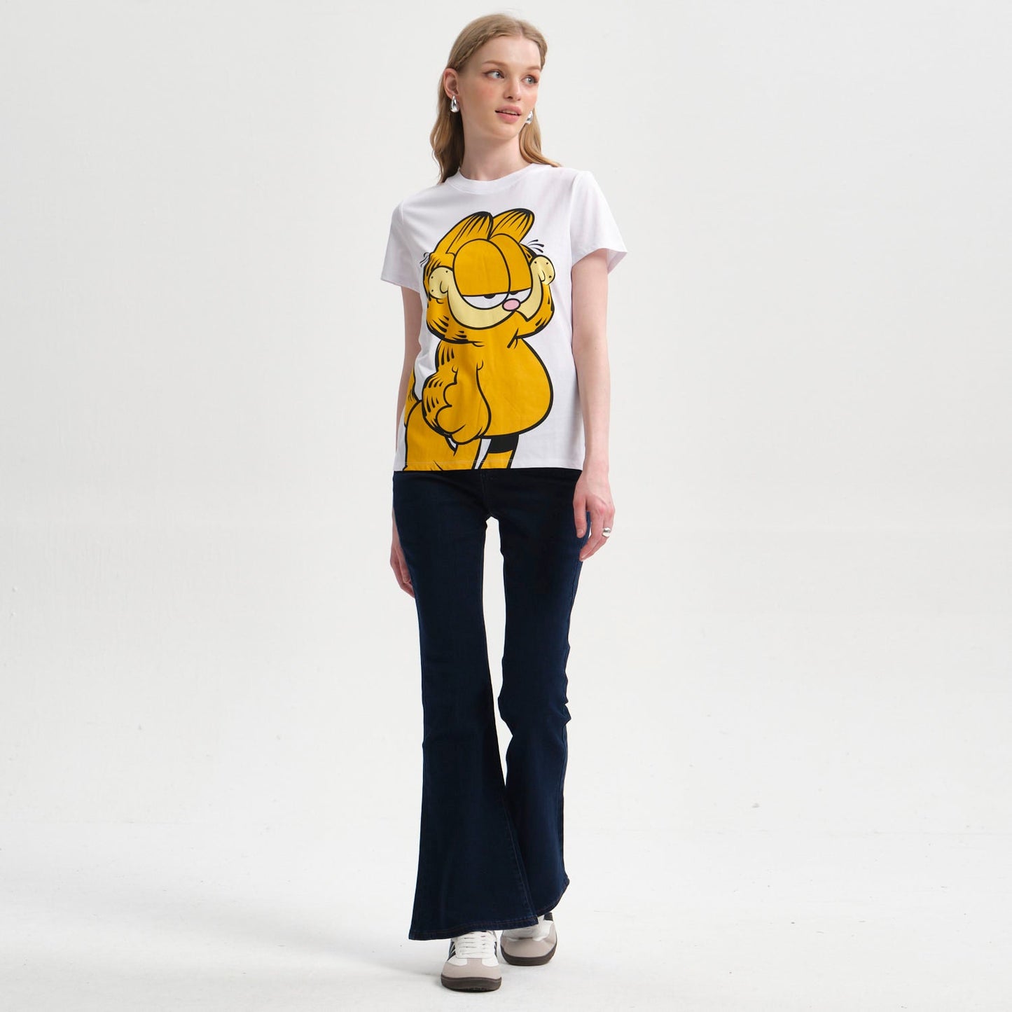 Polera blanca de Garfield con ilustración colorida del icónico gato perezoso en pose relajada, captura la esencia de la tira cómica clásica.