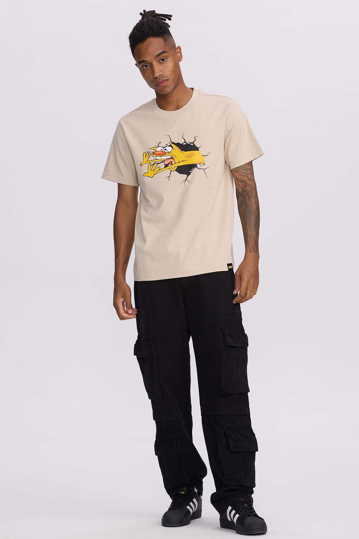 Polera beige de algodón con ilustración de CatDog rompiendo la tela, destacando su personalidad única y divertida, ideal para fans de Nickelodeon.