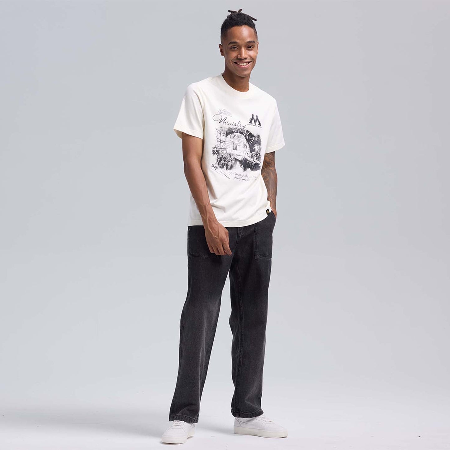 Polera beige de algodón con estampado en blanco y negro del Ministerio de Magia, presenta el icónico edificio y detalles de la comunidad mágica.