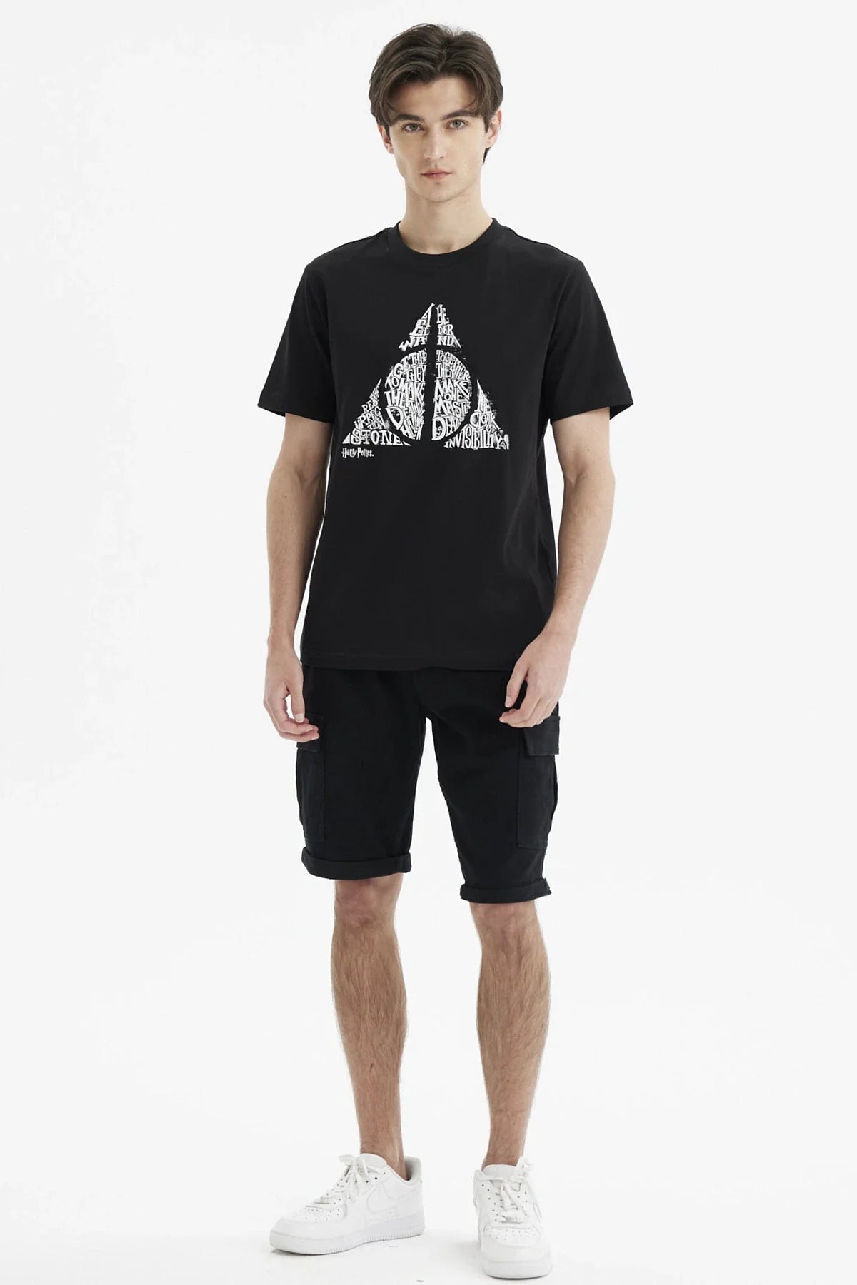 Polera negra de Harry Potter con un diseño en blanco del símbolo de las Reliquias de la Muerte, resaltando palabras icónicas de la saga.