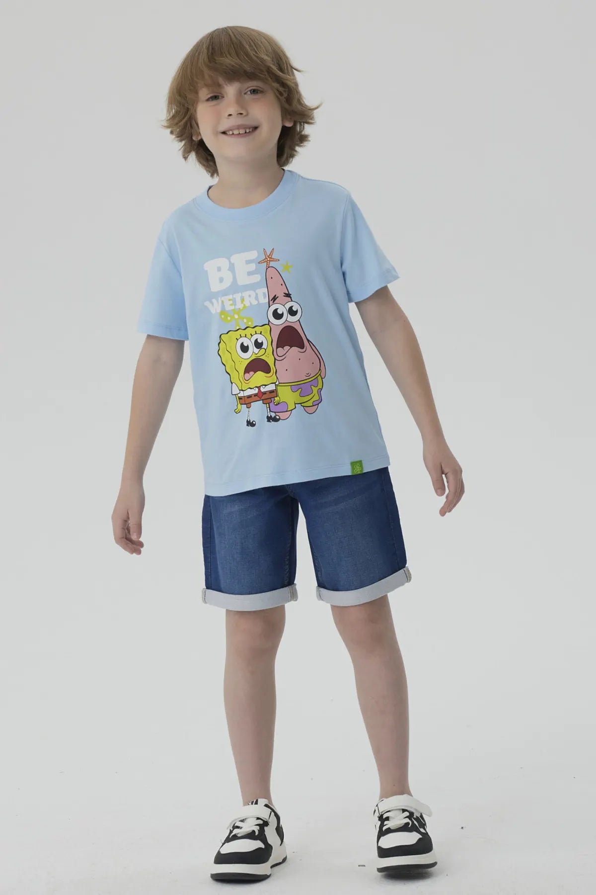 Polera celeste de algodón con estampado de Bob Esponja y Patricio, ambos con expresiones sorprendidas, acompañados del texto 'BE WEIRD', ideal para fans de Nickelodeon.