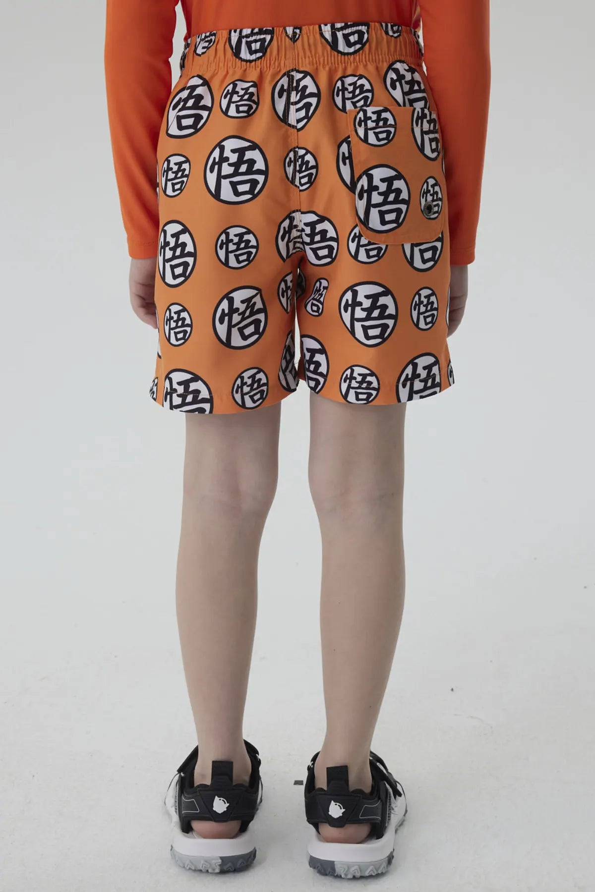 Short de baño naranja con estampado de esferas del dragón en negro, ideal para mostrar tu amor por Dragon Ball mientras disfrutas del verano.