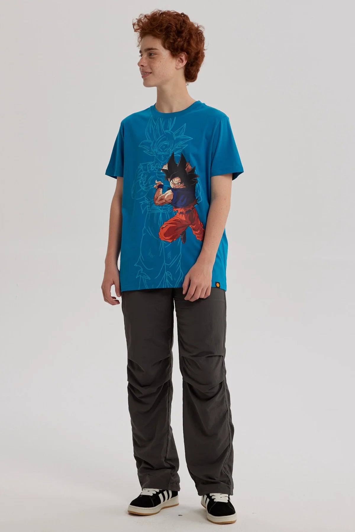 Polera de color calipso con Goku en acción, ilustración vibrante en tonos oscuros, destacando su icónica pose de combate, ideal para fans de Dragon Ball.