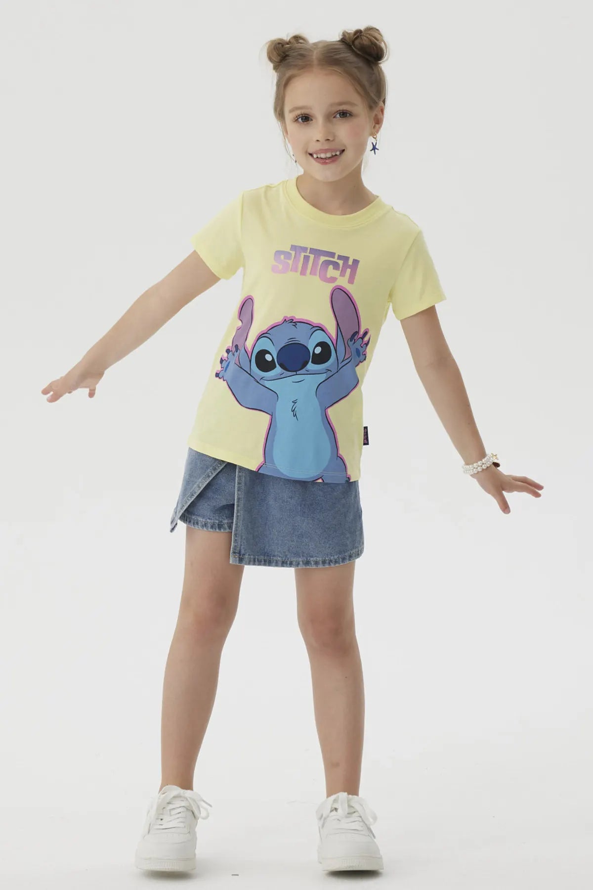 Polera amarilla de algodón con ilustración de Stitch en tonos azules y morados, mostrando su icónica pose alegre, perfecta para fans de Disney.