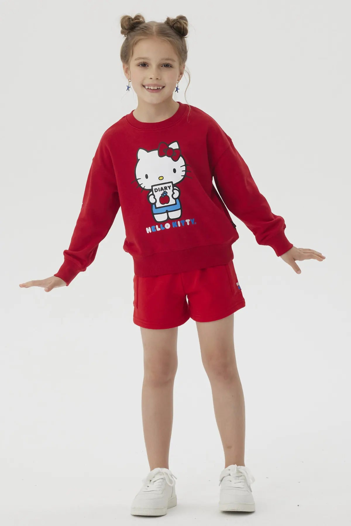 Polerón rojo con ilustración de Hello Kitty sosteniendo un diario, con detalles en azul y el texto 'HELLO KITTY' en la parte inferior, ideal para fans de la icónica gatita.