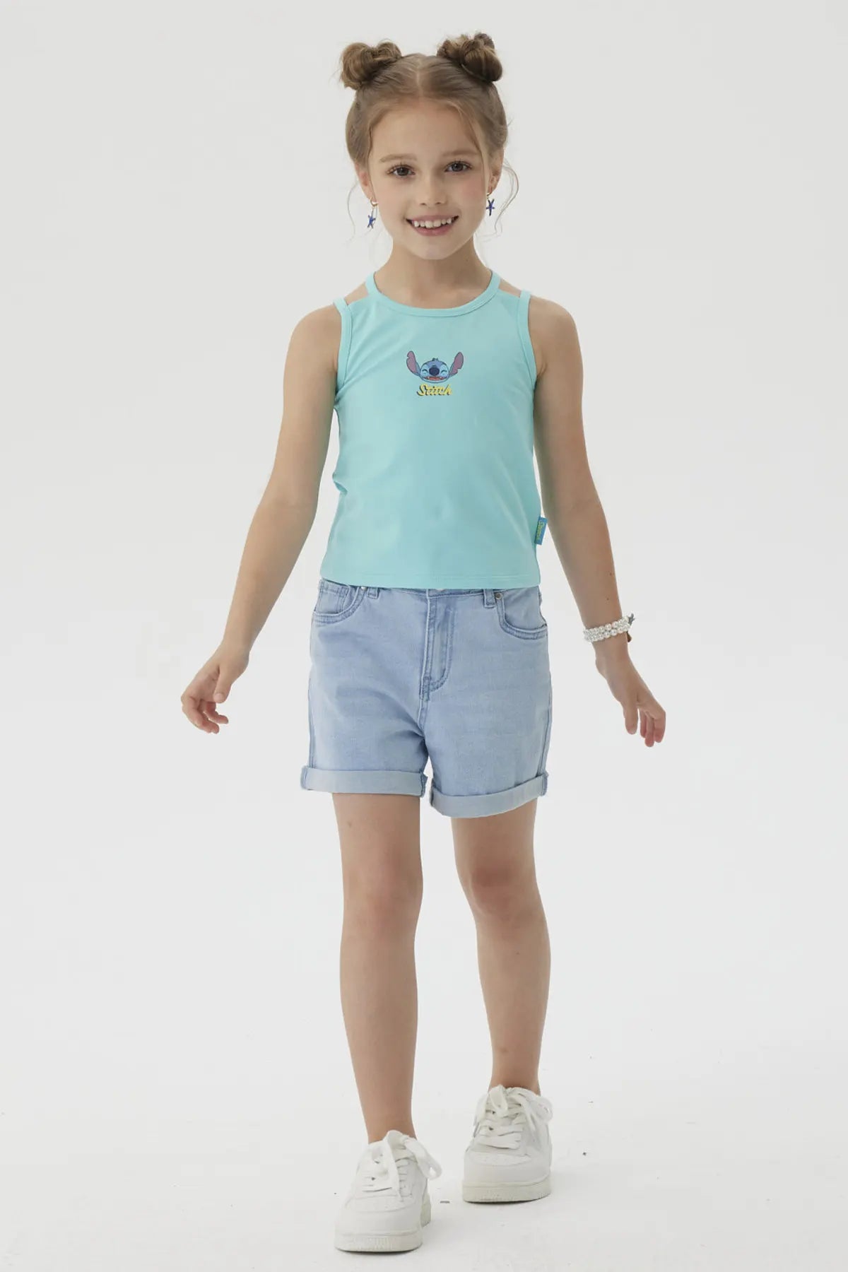 Polera celeste de algodón con estampado de Stitch en estilo cartoon, mostrando al personaje feliz con brazos abiertos y la palabra 'Stitch' debajo, ideal para fans de Disney.