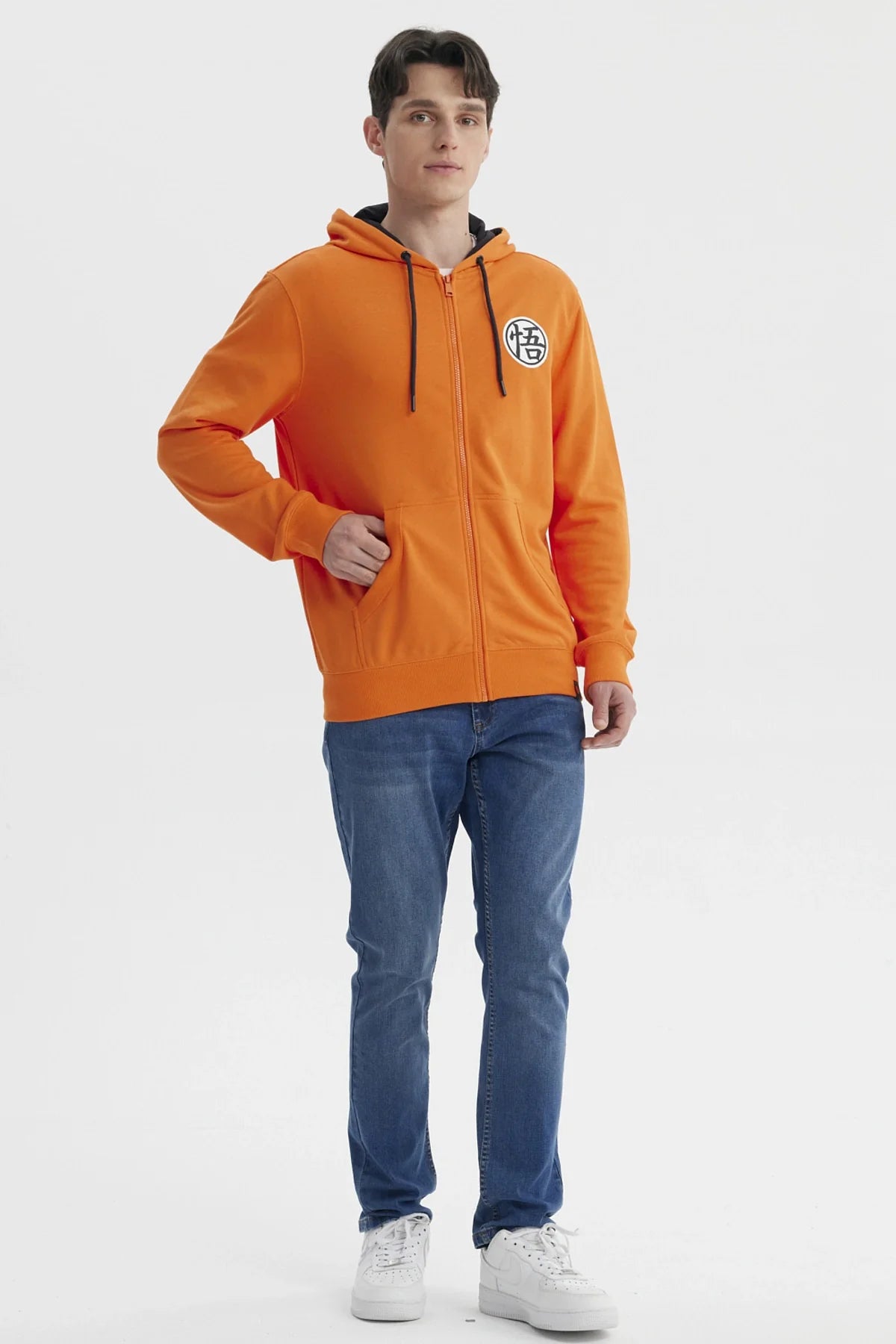 Polerón naranjo con capucha de Dragon Ball, presenta el icónico símbolo de Goku en el pecho, ideal para fanáticos de la saga.