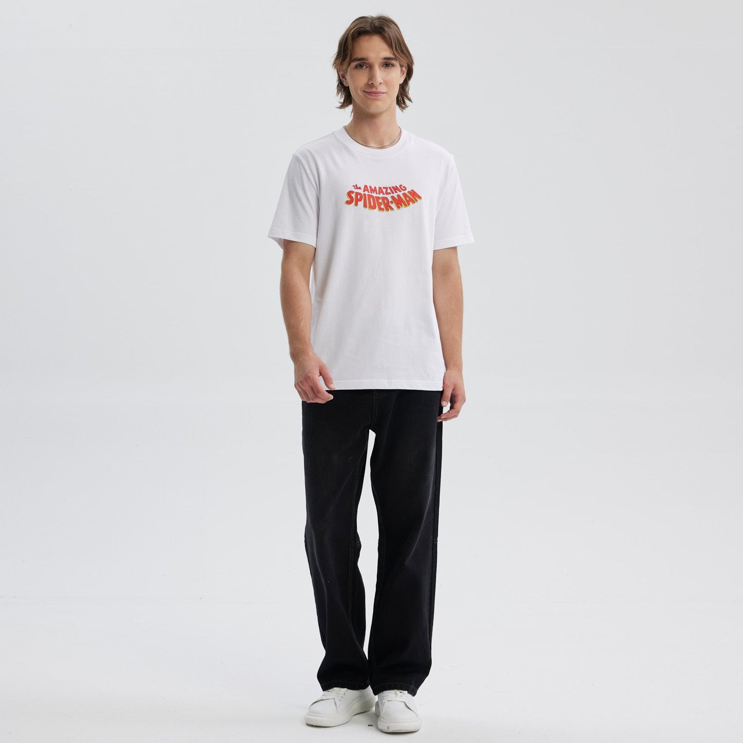Polera blanca de algodón con el texto "the AMAZING SPIDER-MAN" en un vibrante estilo retro, ideal para los fans del icónico héroe de Marvel.
