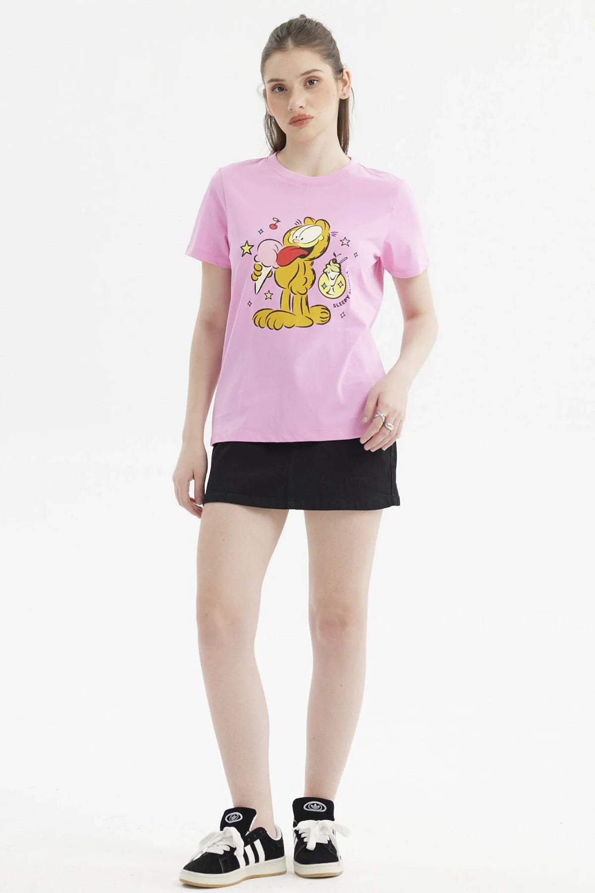 Polera rosada de Garfield con ilustración colorida del gato sosteniendo un helado, rodeado de estrellas y cerezas, perfecta para fans del cómic.
