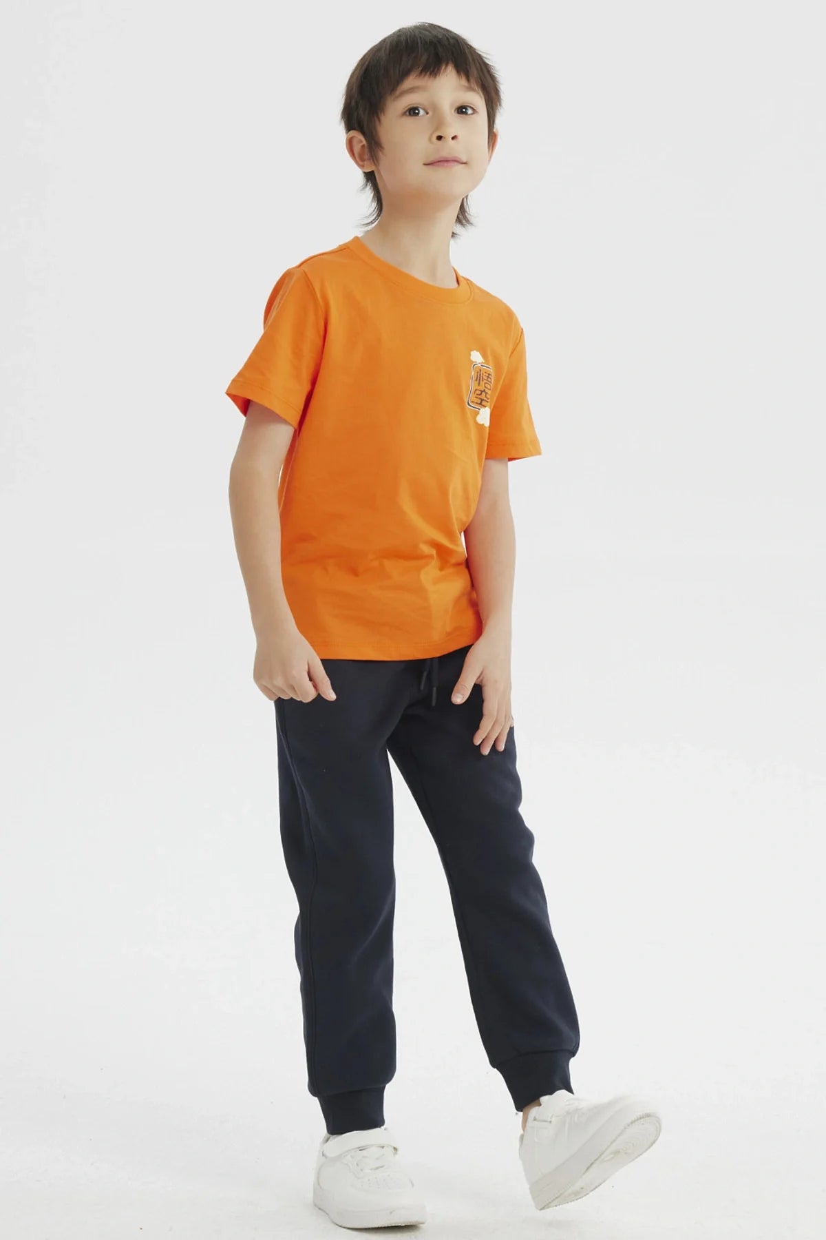 Polera naranja de Dragon Ball Z con estampado frontal de kanji en negro y nubes, ideal para los pequeños guerreros del universo Akira Toriyama.