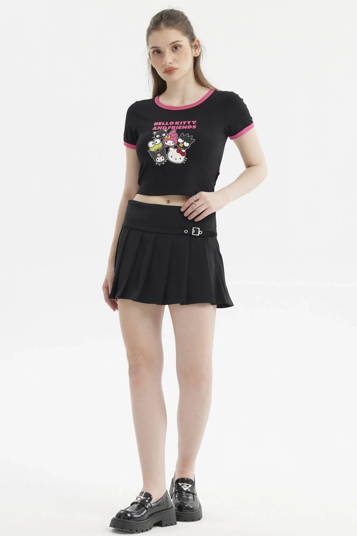 Polera negra de Hello Kitty con ribete rosa, presenta un diseño vibrante de Hello Kitty y sus amigos en estilo cartoon, ideal para fans de Sanrio.