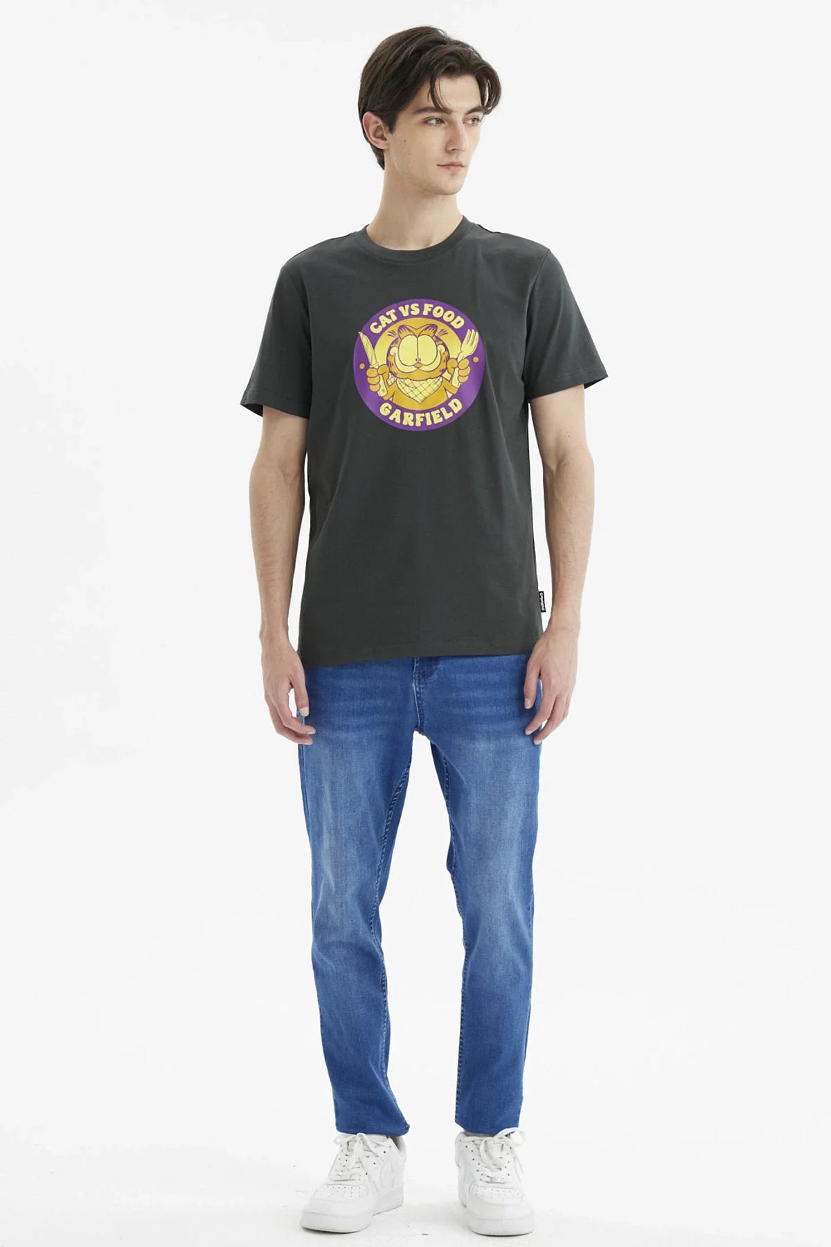 Polera Garfield Marengo en color gris oscuro con un diseño divertido de Garfield sosteniendo cuchillo y tenedor, resaltando su amor por la comida en un estilo gráfico vibrante.