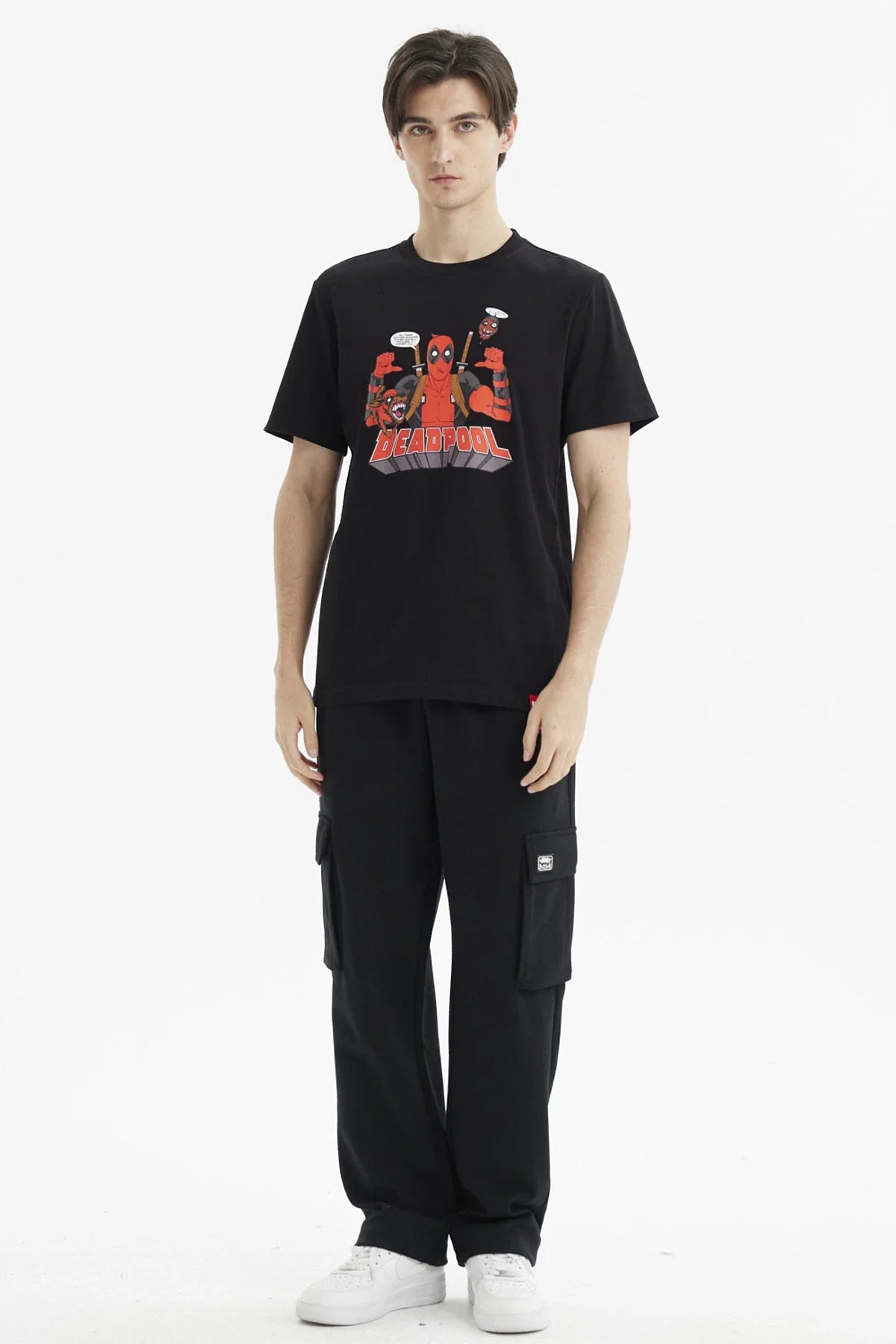 Polera negra de algodón con ilustración de Deadpool en el centro, mostrando su icónico traje rojo y negro, acompañado de personajes cómicos, en estilo caricaturesco.