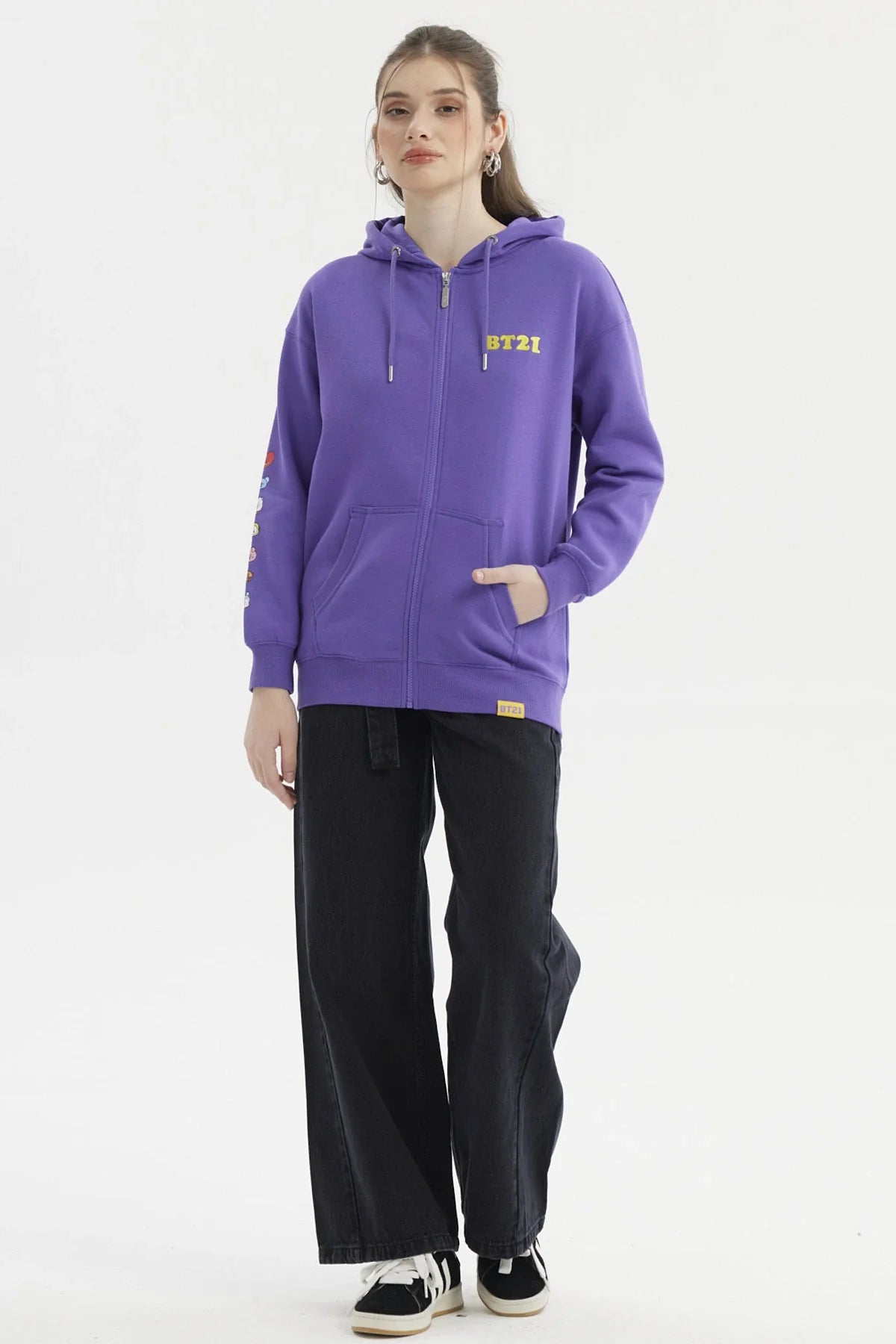 Polerón violeta con cierre, logo BT21 en amarillo, detalles de personajes en la manga, ideal para fans de BTS y su universo creativo.