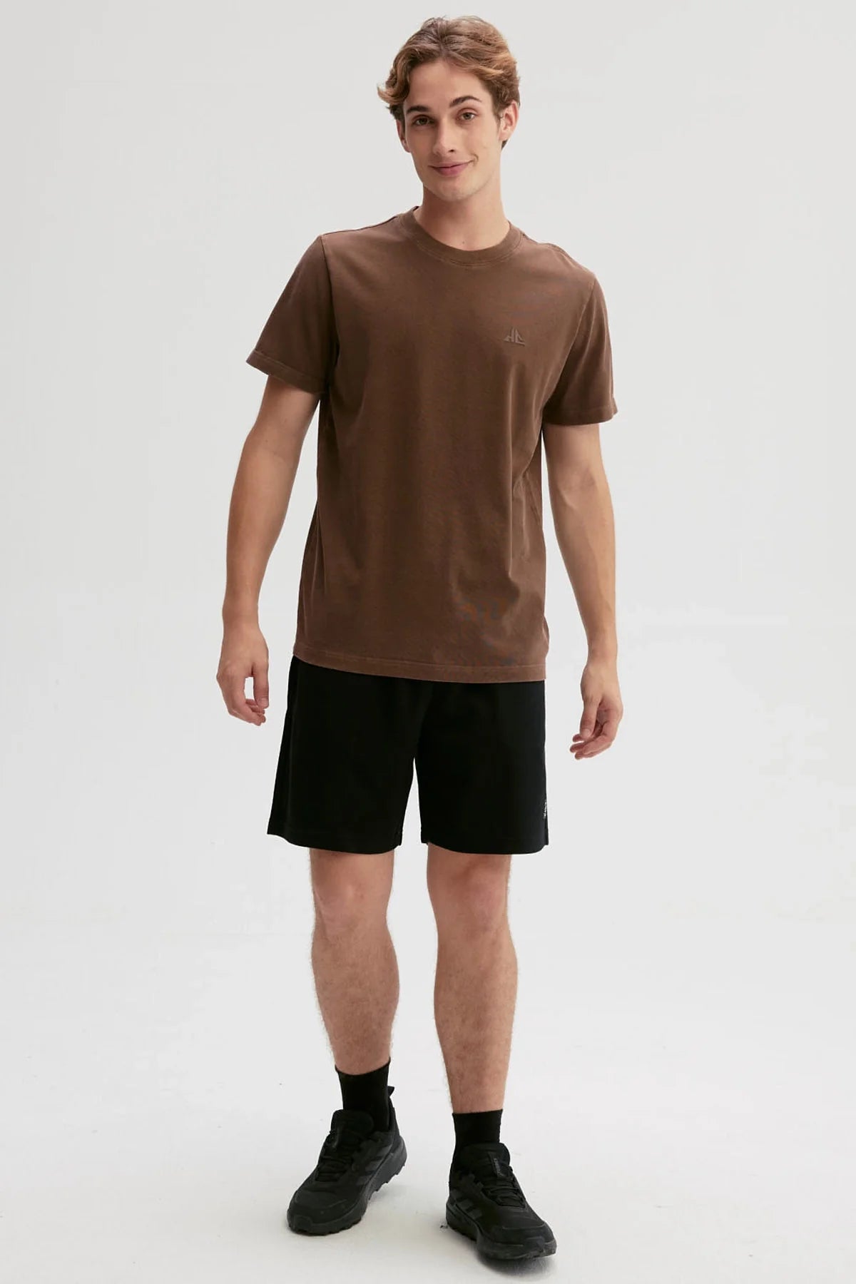 Polera de algodón marrón con un sutil logo en relieve, ideal para los fanáticos del café y la cultura pop, perfecta para mostrar tu estilo único.