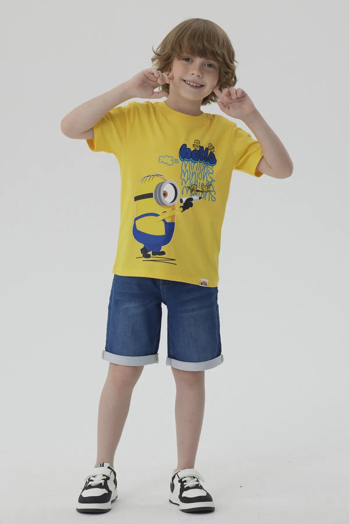 Polera amarilla de algodón con un Minion caricaturesco sosteniendo un lápiz, acompañado de un texto divertido en azul, ideal para fans de la saga Despicable Me.