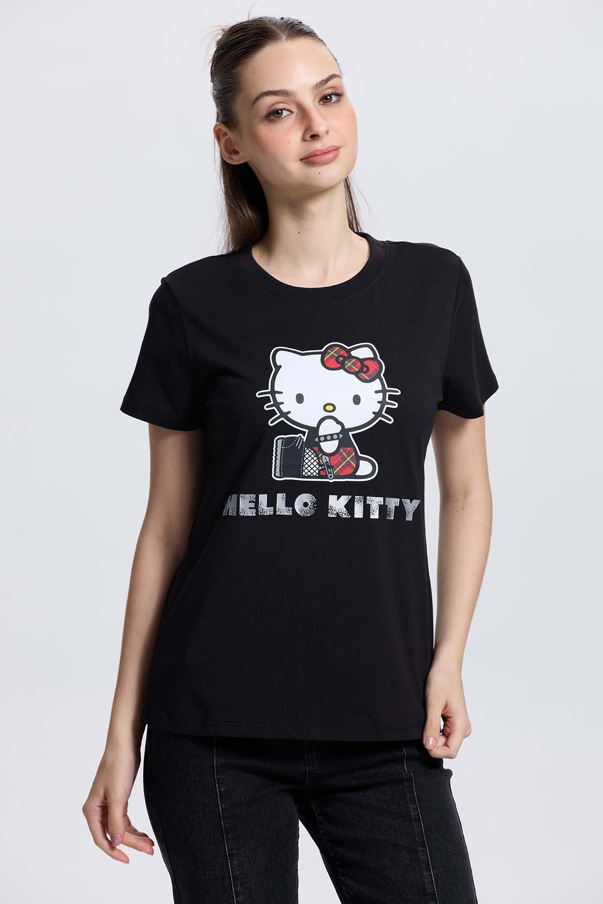 Polera negra de algodón con ilustración de Hello Kitty en un estilo moderno, mostrando a la icónica gatita con un lazo rojo y un micrófono, perfecta para fans.