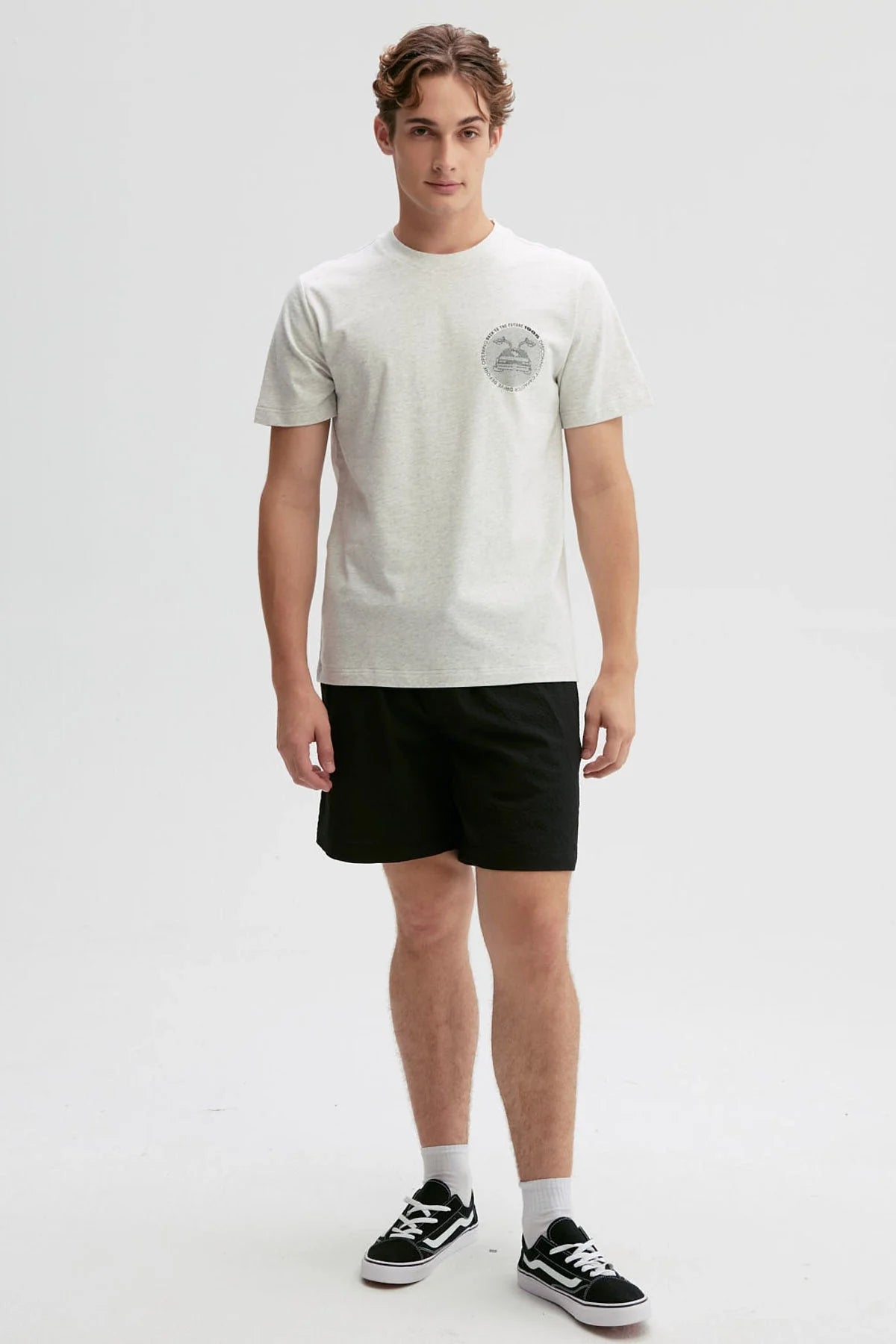Polera gris de algodón con un diseño minimalista que presenta la icónica DeLorean de 'Volver al Futuro' y el texto 'Roads? Where we're going we don't need roads'.