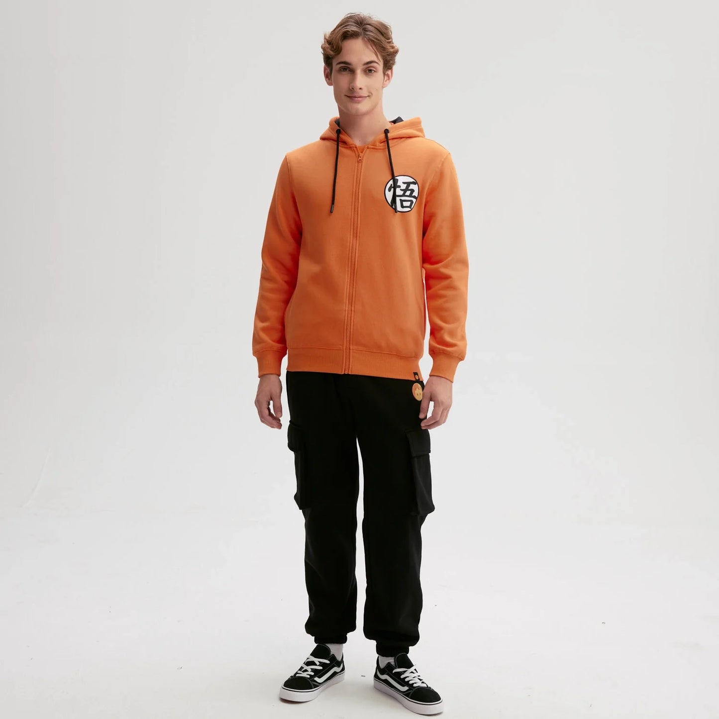 Polerón naranjo de Dragon Ball con capucha, presenta el icónico símbolo de Goku en el pecho, ideal para fans del universo Shonen.
