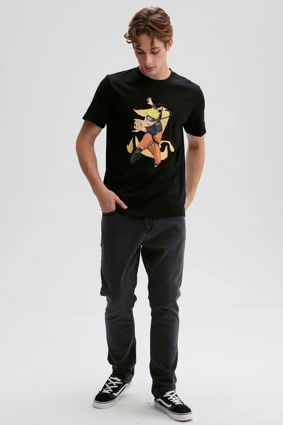 Polera negra de Naruto Shippuden con un diseño vibrante de Naruto en acción, mostrando su característico cabello rubio y vestimenta naranja, en un fondo dinámico.