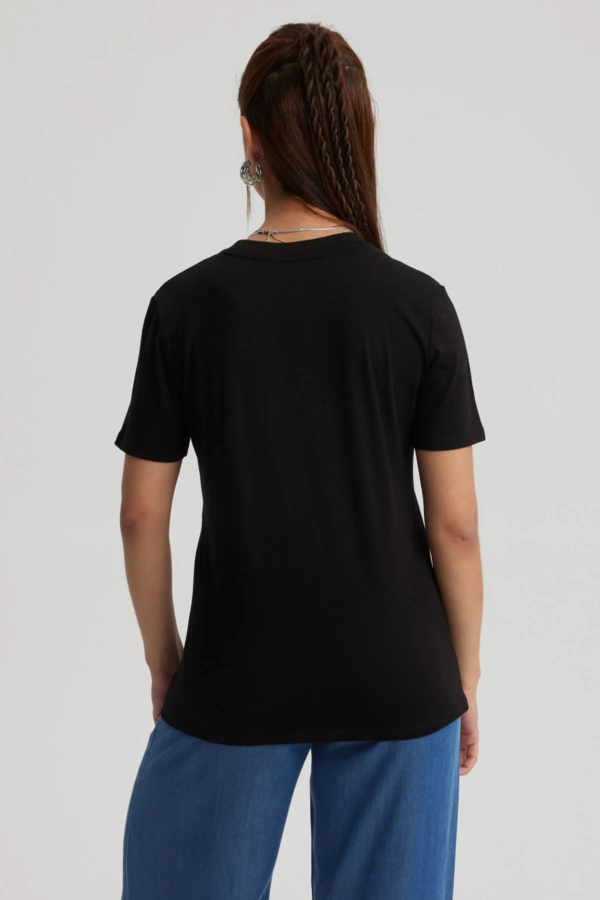 Polera negra de algodón con un diseño dorado y rojo que muestra la icónica torre del reloj de Hogwarts, evocando la magia de Harry Potter.