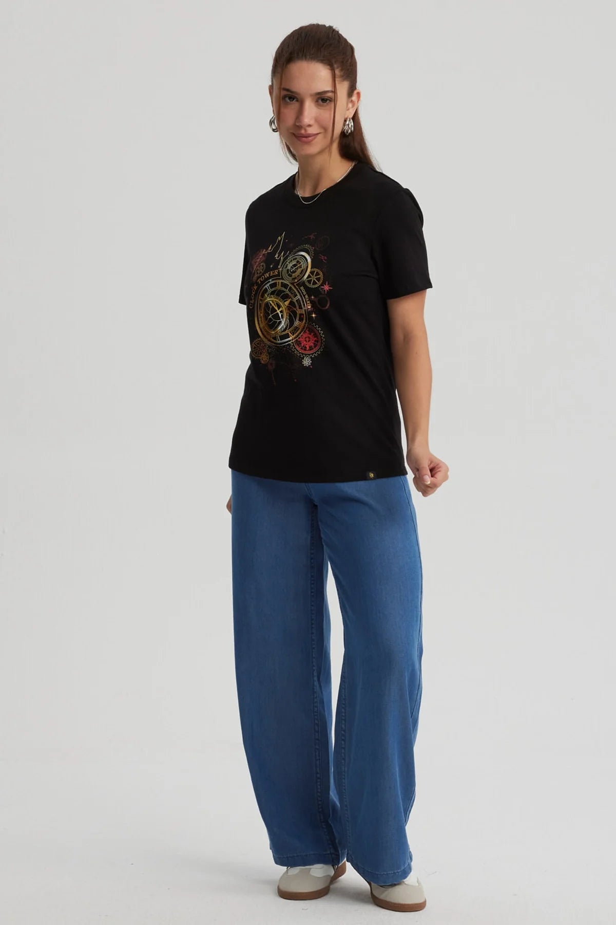 Polera negra de algodón con un diseño dorado y rojo que muestra la icónica torre del reloj de Hogwarts, evocando la magia de Harry Potter.
