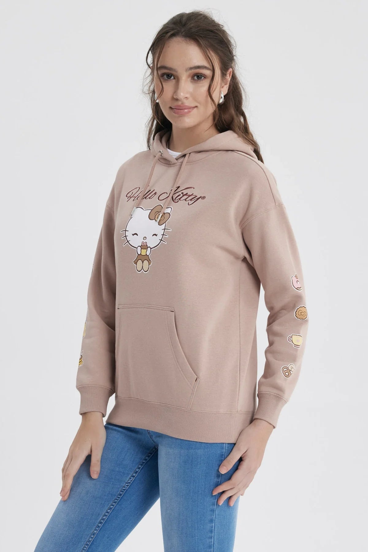 Polerón rosa con capucha de Hello Kitty, presenta un diseño de la icónica gatita sosteniendo un dulce en el centro y pequeños íconos de comida en las mangas.