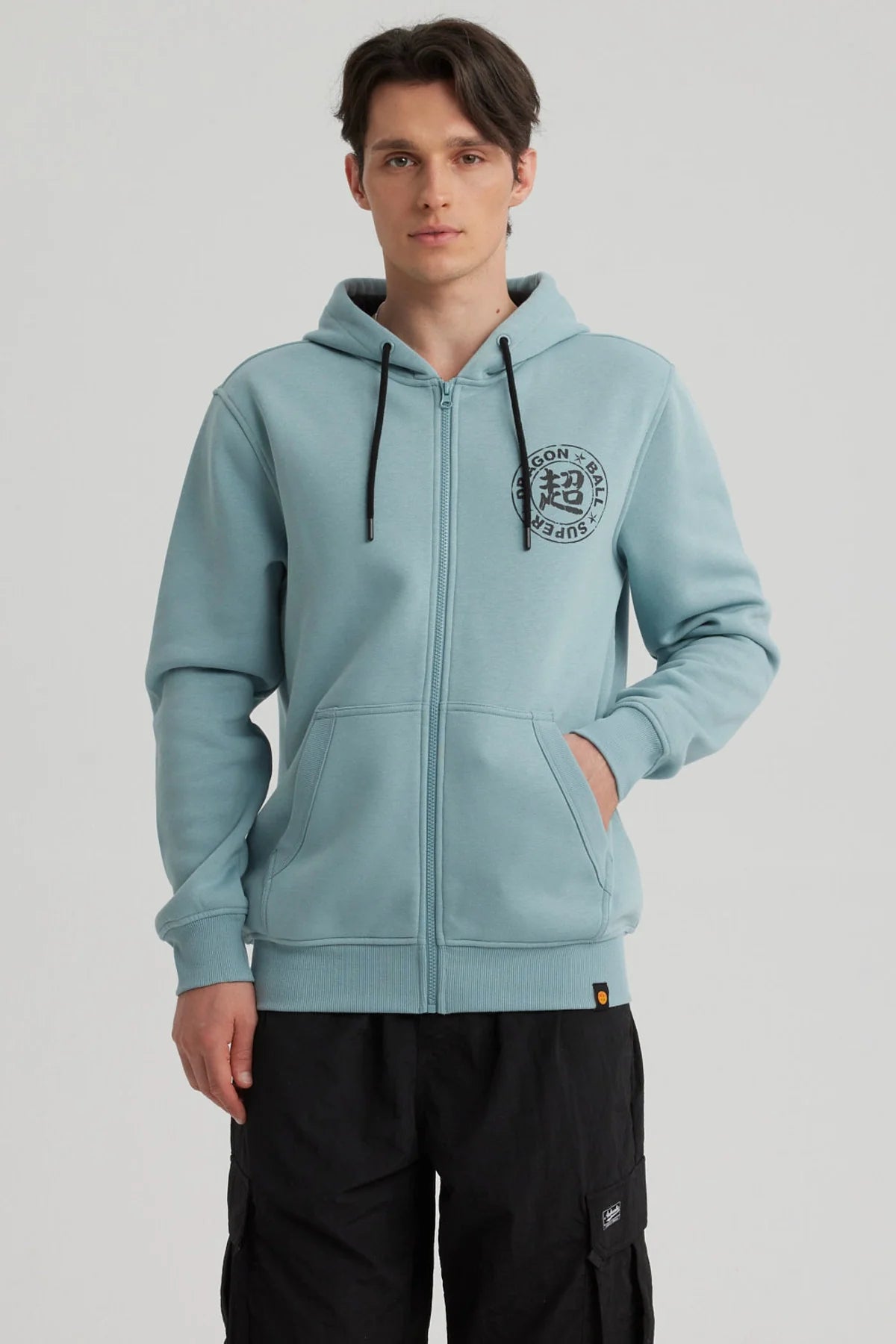 Polerón azul claro de Dragon Ball con capucha, presenta un logo negro en el pecho, ideal para fans de Vegetto en un look casual y cómodo.