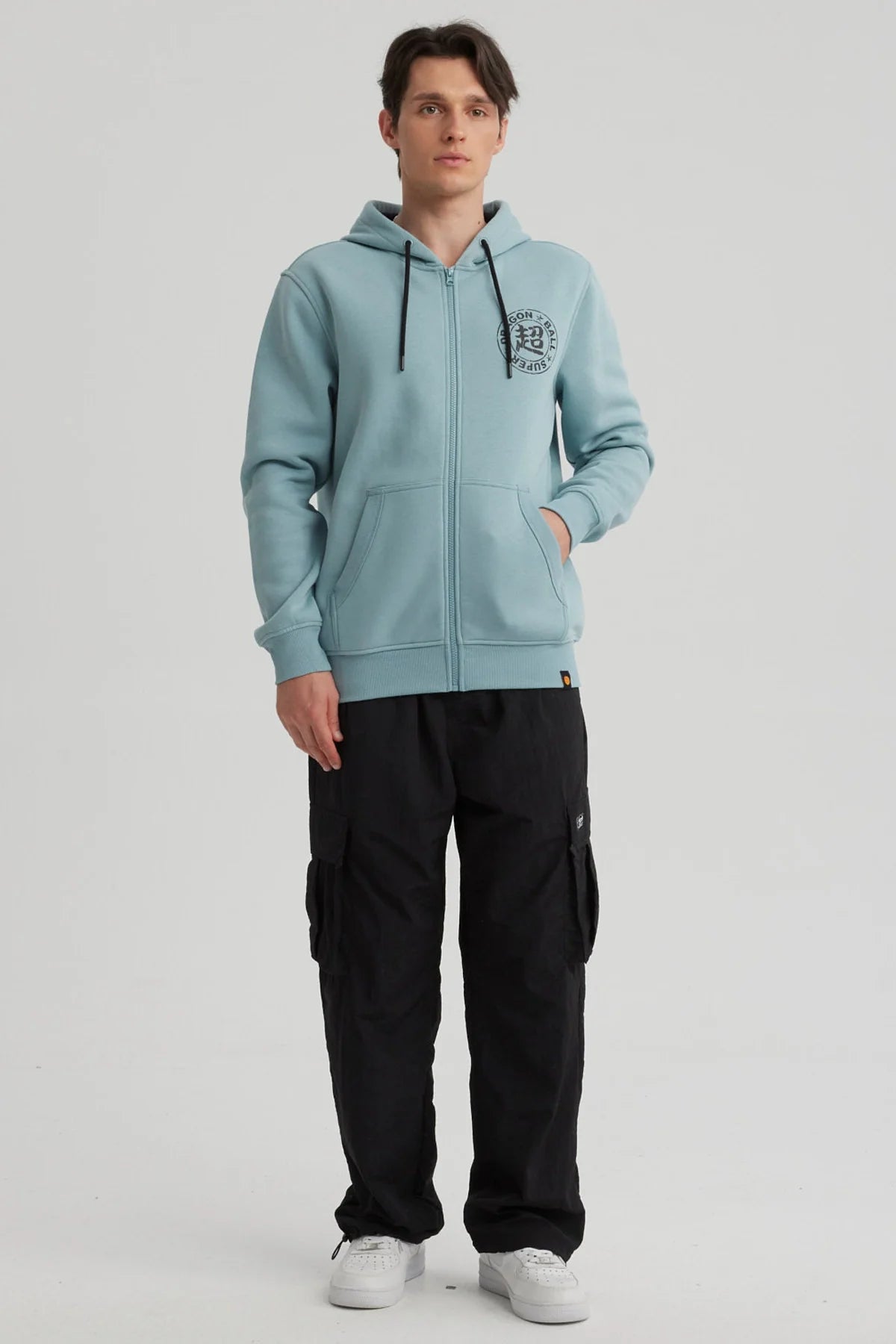 Polerón azul claro de Dragon Ball con capucha, presenta un logo negro en el pecho, ideal para fans de Vegetto en un look casual y cómodo.