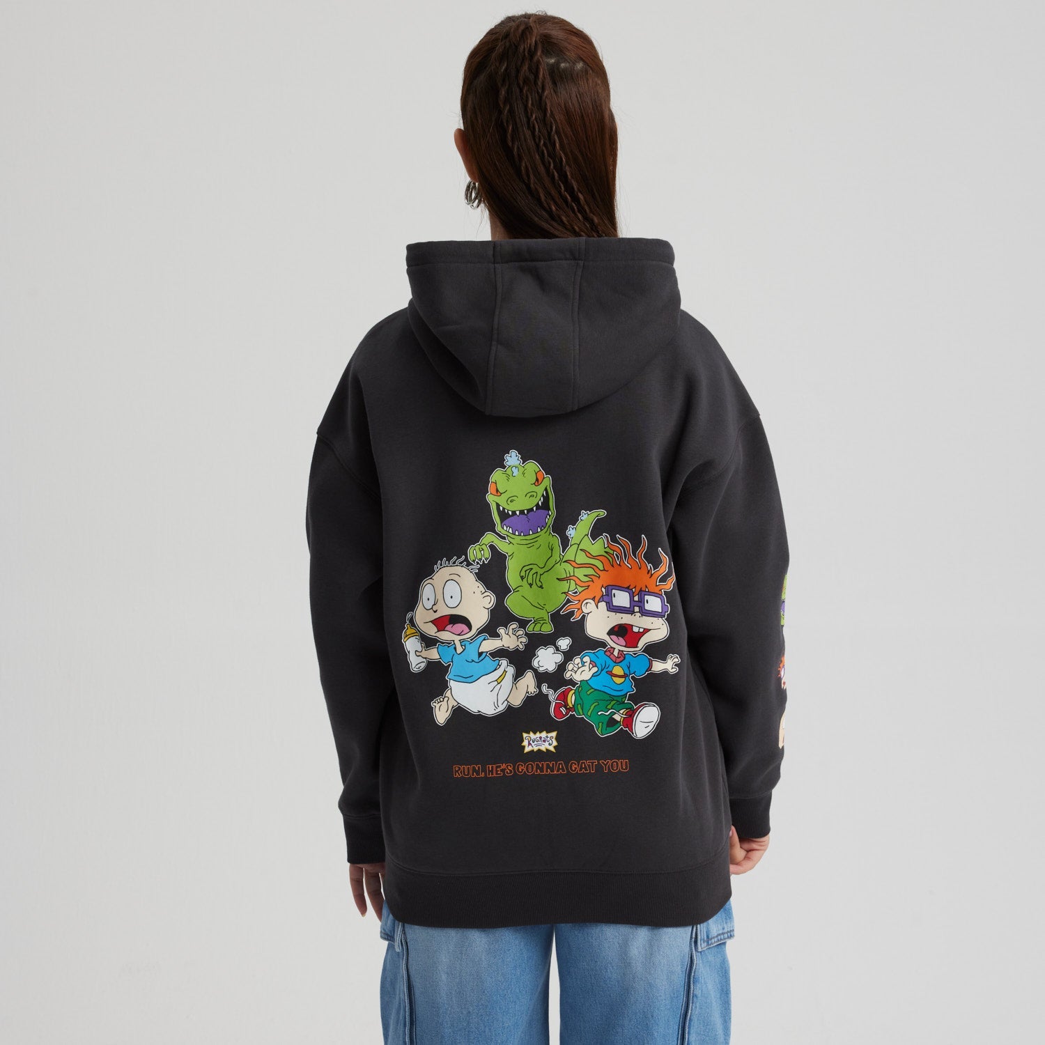 Polerón negro con capucha y cierre, presenta el logo de Rugrats en el pecho y personajes icónicos en las mangas, ideal para fans de la serie.