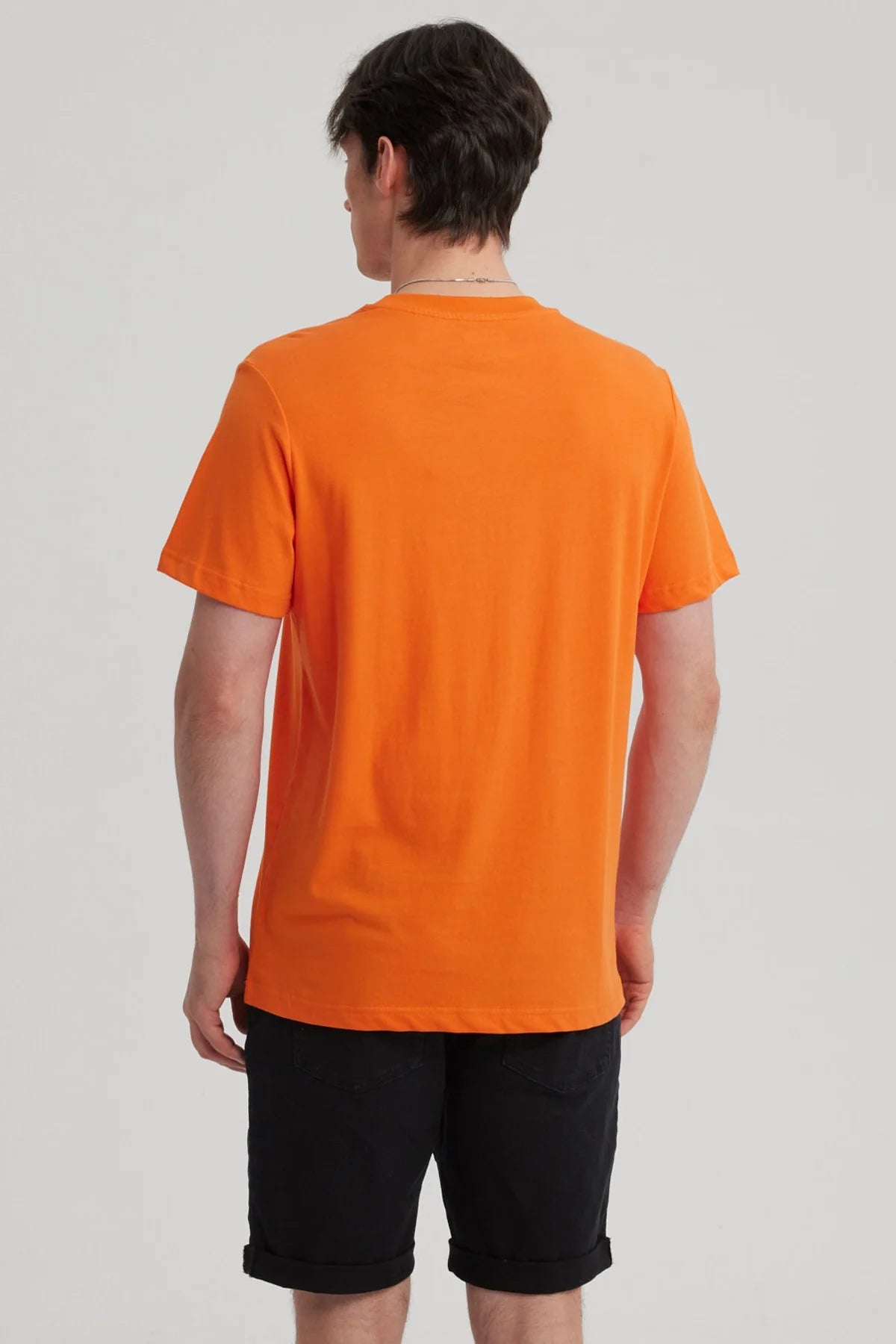 Polera naranjo de Dragon Ball con ilustración de Goku en acción, destacando su icónico cabello negro y traje azul, ideal para fans de la saga.