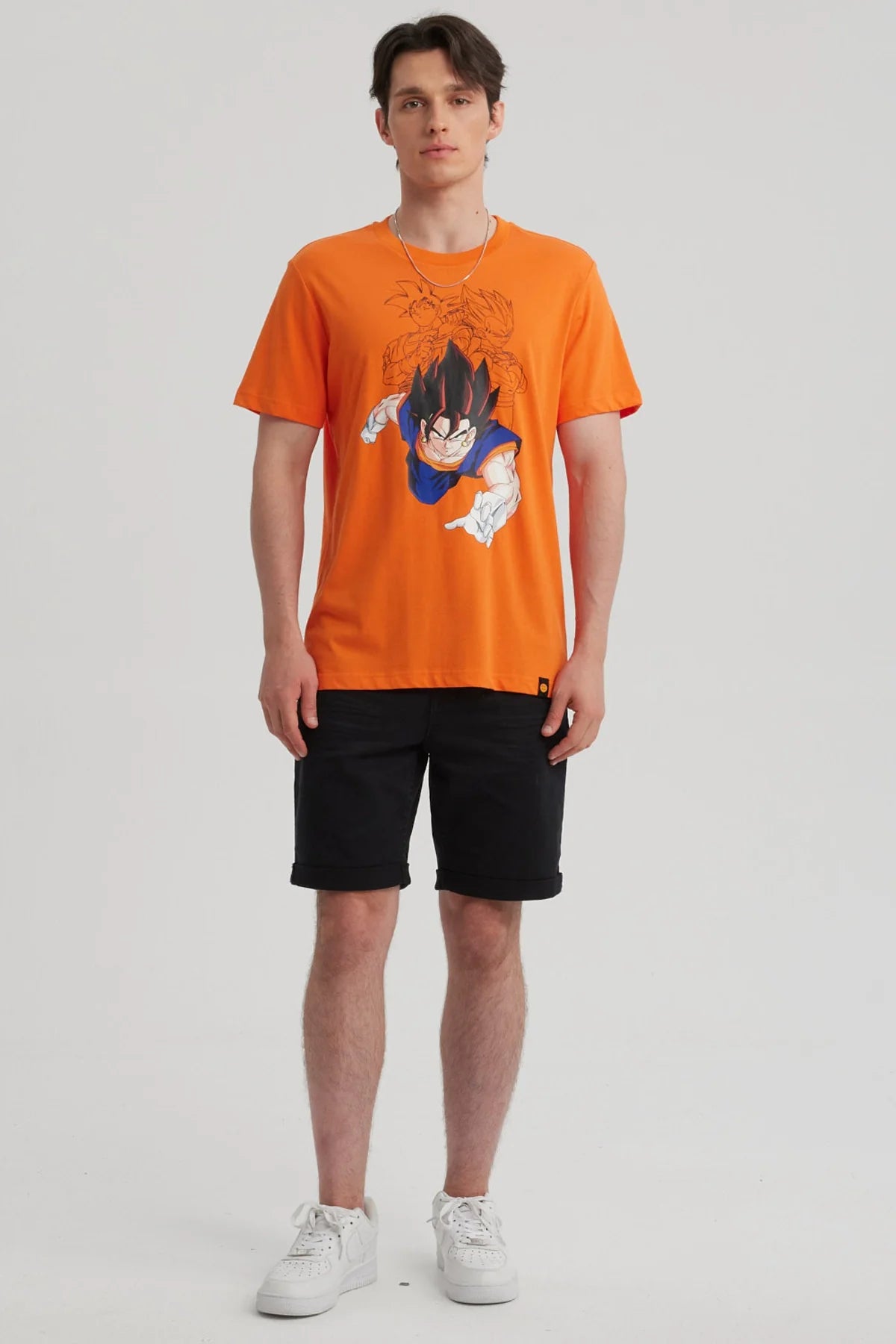 Polera naranjo de Dragon Ball con ilustración de Goku en acción, destacando su icónico cabello negro y traje azul, ideal para fans de la saga.