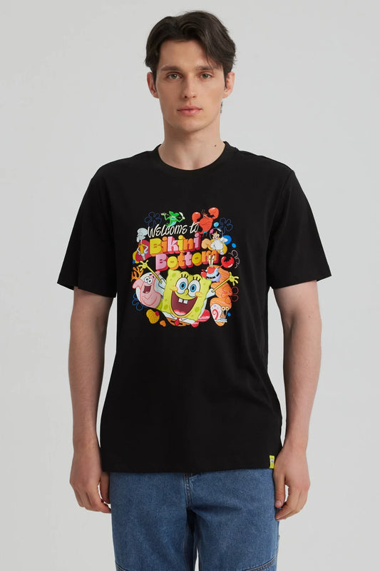 Polera negra de algodón con estampado colorido de Bob Esponja y amigos, mostrando la frase 'Welcome to Bikini Bottom' en un diseño vibrante y divertido.