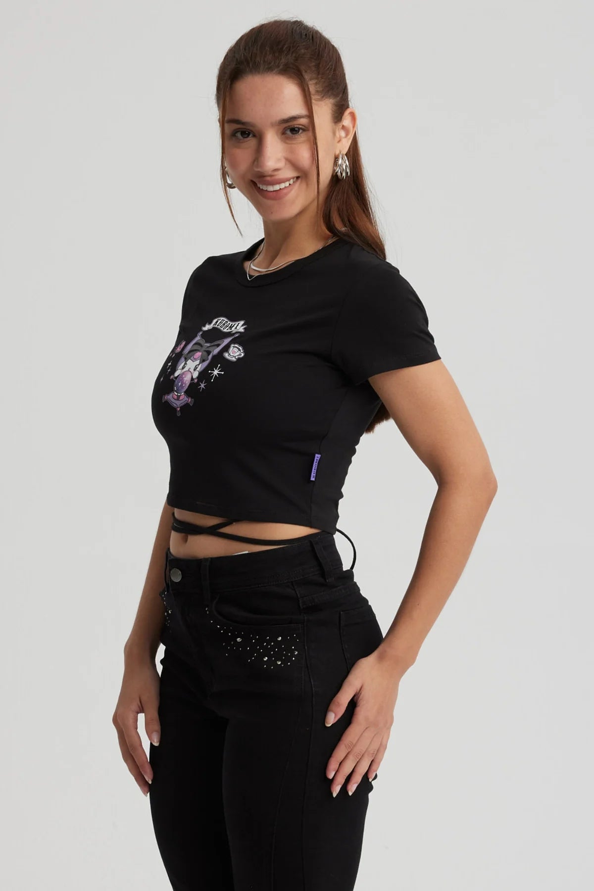 Polera negra ajustada con estampado de Kuromi en tonos morados y rosa, mostrando a la icónica personaje en acción, perfecta para fans de Sanrio.