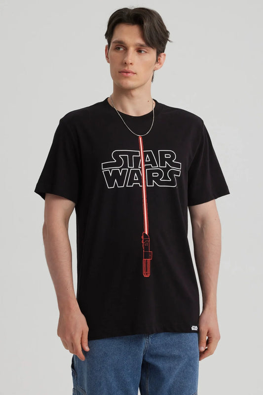 Polera negra de algodón con el logo de Star Wars en blanco y un sable de luz rojo en el centro, ideal para fans de la saga galáctica.