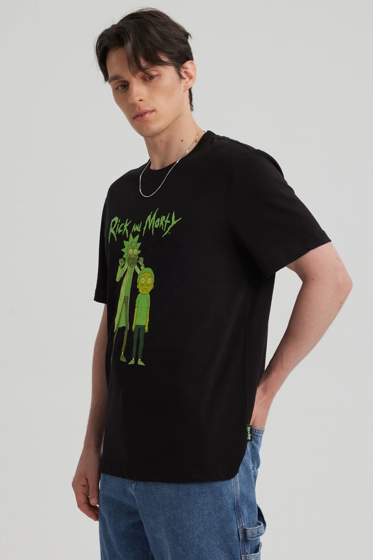 Polera negra de algodón con ilustración de Rick y Morty en verde, mostrando a Rick con su expresión característica y Morty luciendo asustado, ideal para fans de la serie.