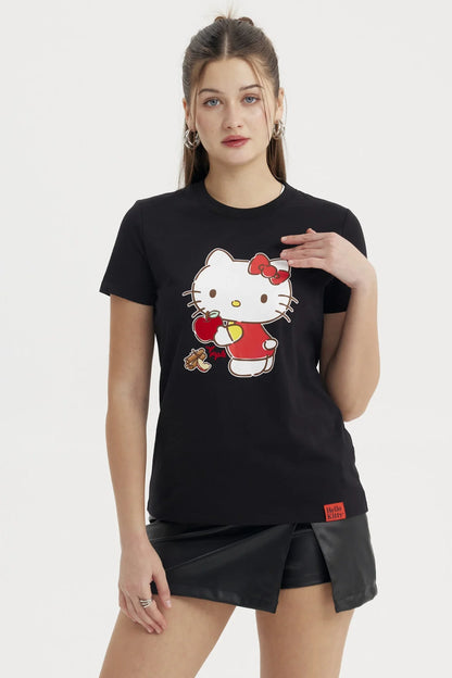 Polera negra de algodón con un diseño colorido de Hello Kitty sosteniendo una manzana roja, con un estilo kawaii que resalta su ternura icónica.